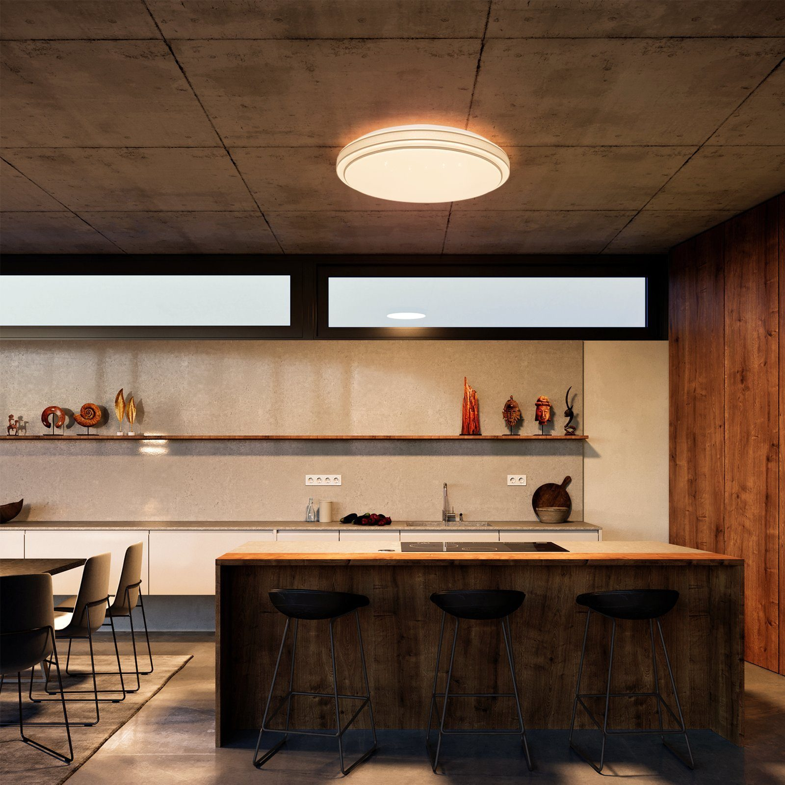 Cocina moderna con techo de hormigón y una isla de madera con taburetes. Lámpara arriba. Colores neutros.