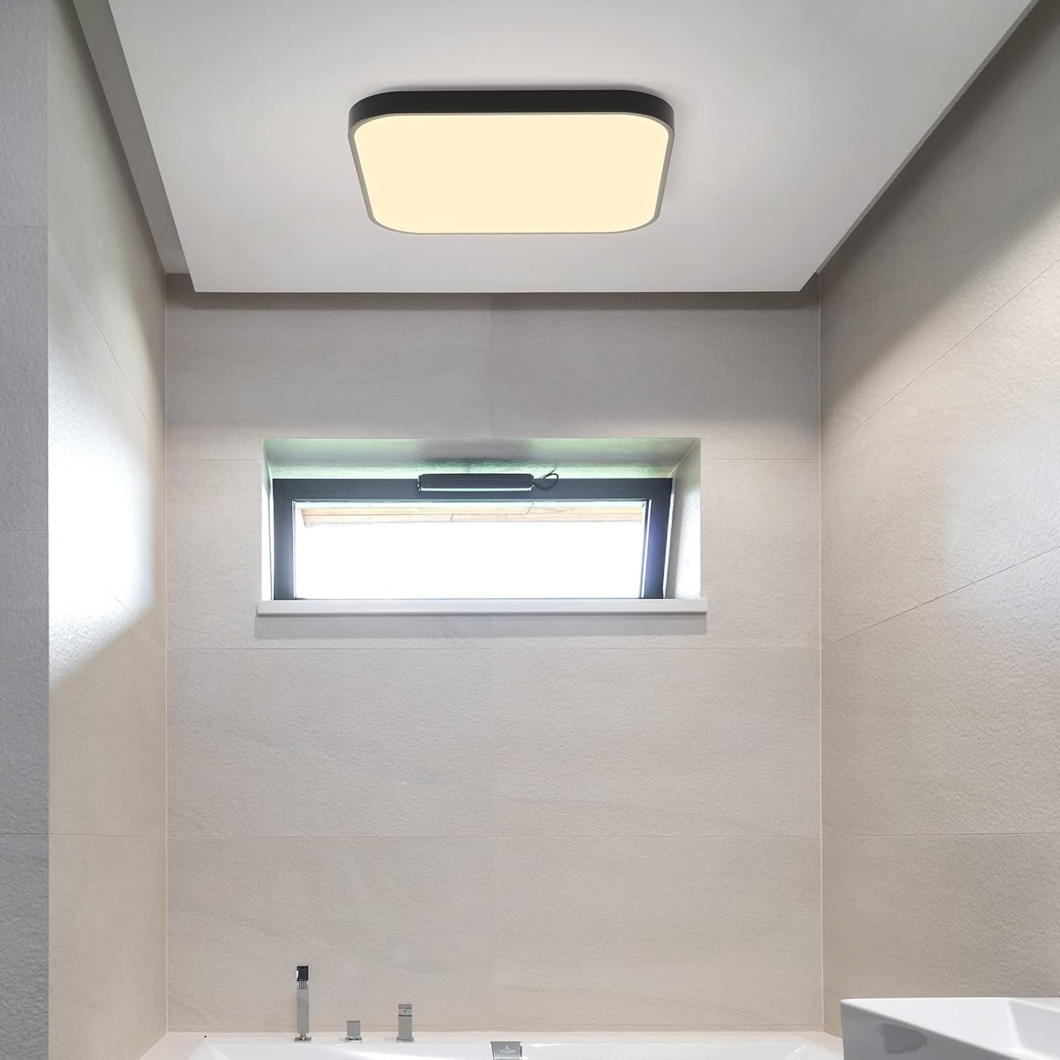 Lampa sufitowa o prostokątnym kształcie i okno w kafelkowej łazience.