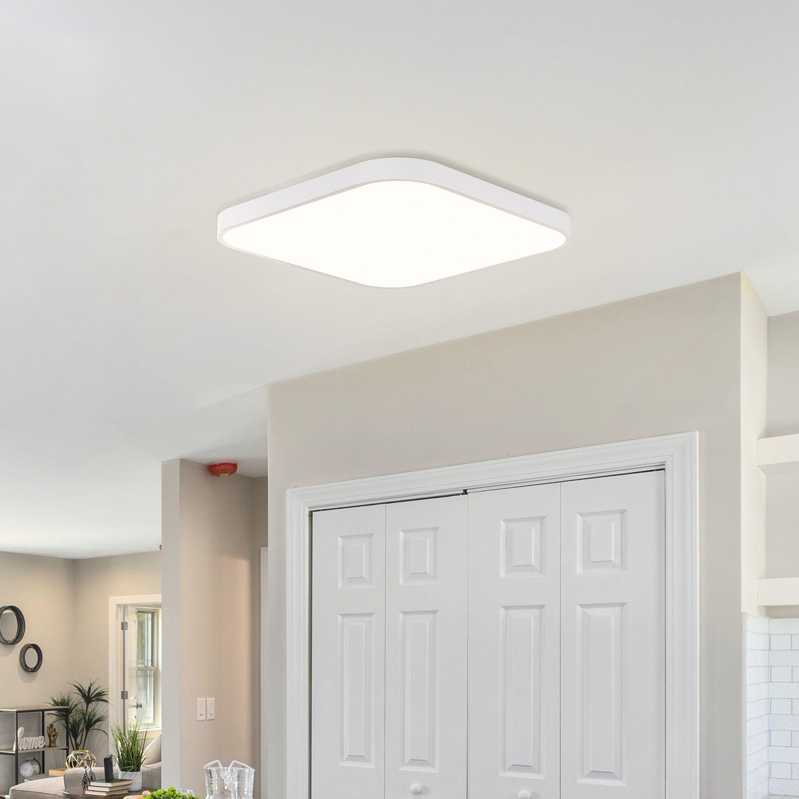 Biała kwadratowa oprawa oświetleniowa sufitowa. Wpuszczana w sufit. Widok od dołu do góry.