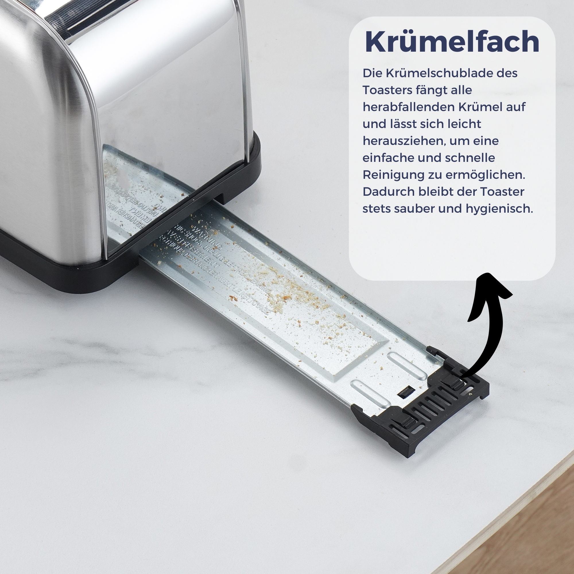 Ein Toaster aus Edelstahl mit herausgezogener Krümelschublade, die Brotkrümel zeigt.