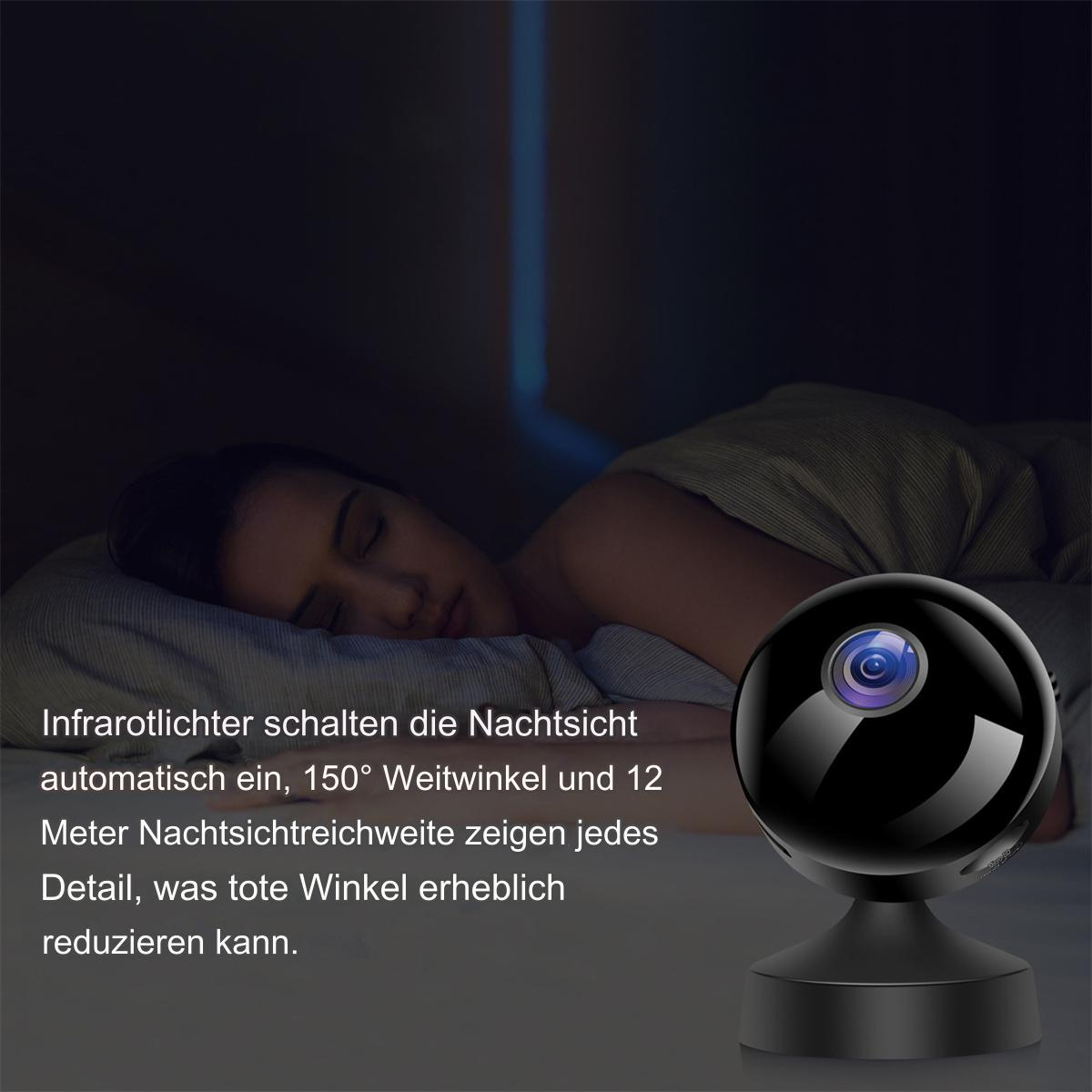 Eine kleine, schwarze Überwachungskamera. Im Hintergrund schläft eine Frau.