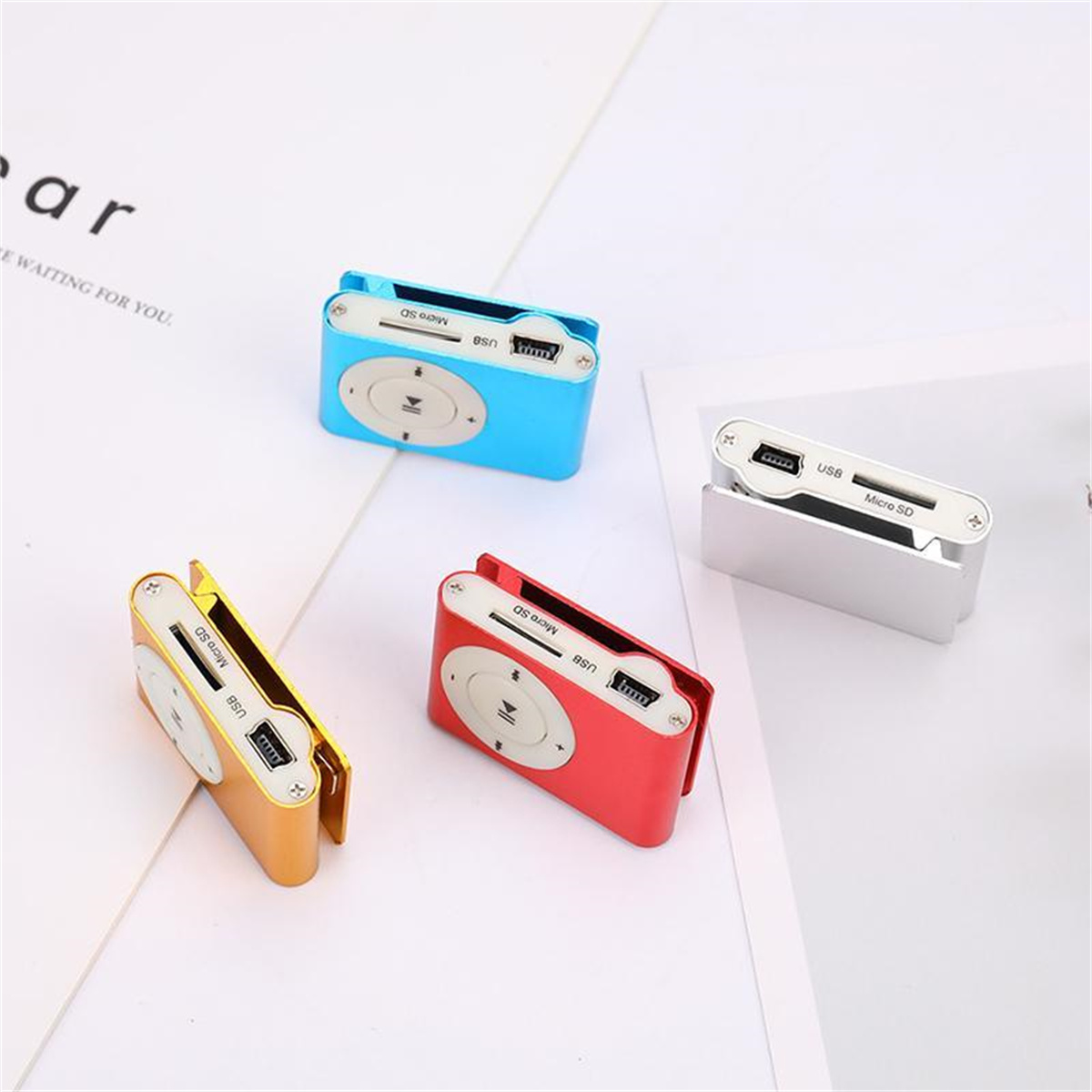 Vier bunte MP3-Player: blau, gelb, rot und silber auf weißem Untergrund.