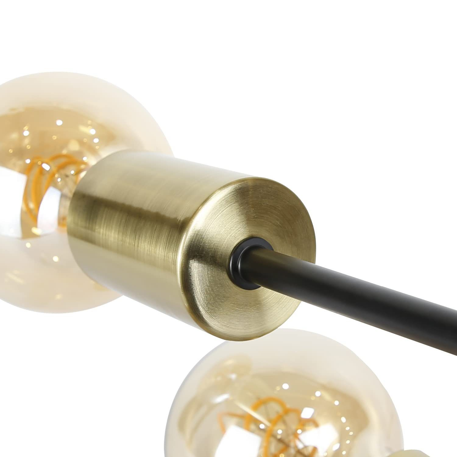 Primo piano di un moderno apparecchio di illuminazione con due lampadine luminose e un giunto centrale color ottone.