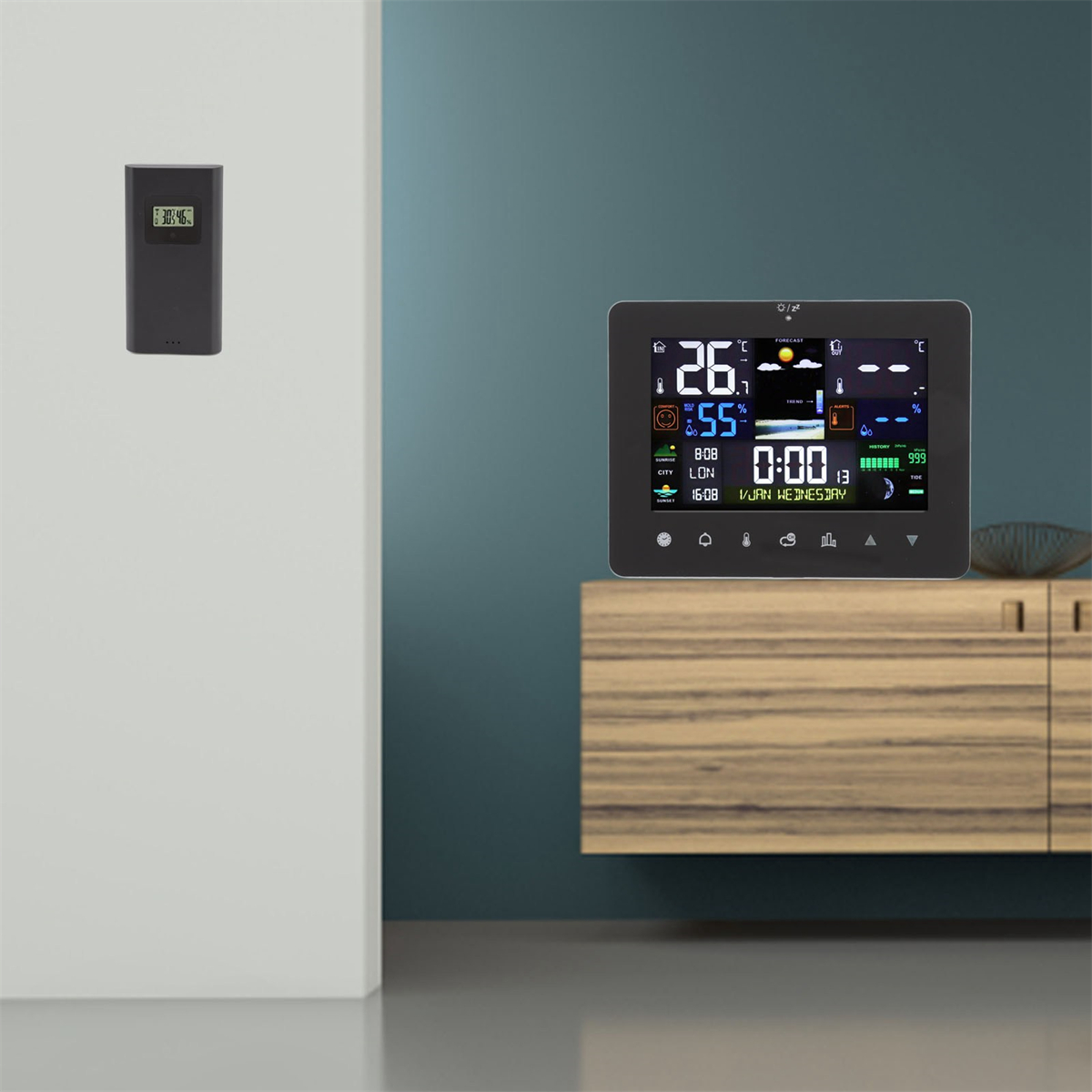Digitale Wetterstation an einer Wand und ein kleiner Bildschirm auf einem Schrank. Die Station zeigt Daten.