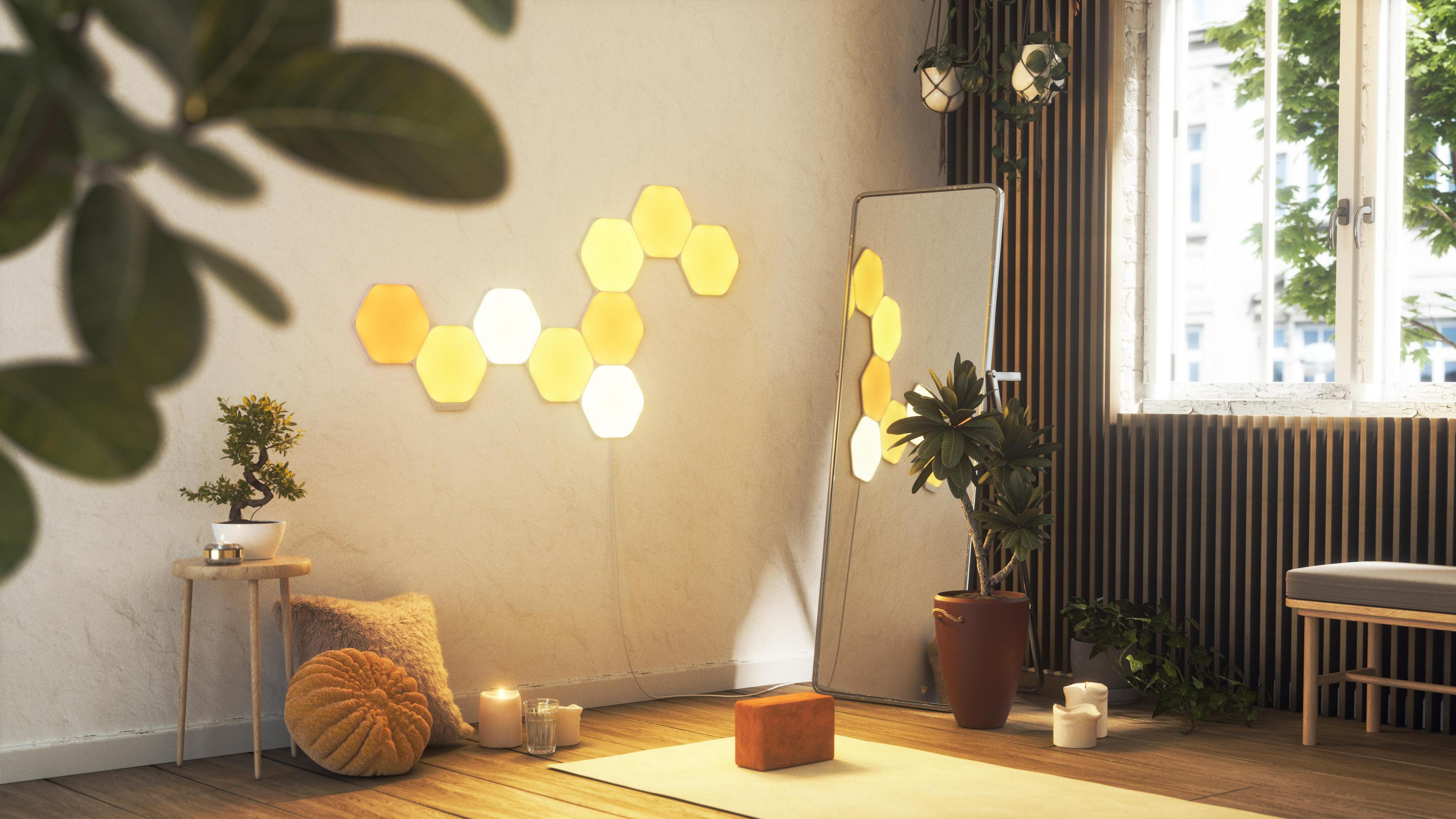 Ein Raum mit LED-Hexagon-Lichtern und einem Spiegel. Eine Yogamatte und Kerzen liegen auf dem Boden. Sonnig.