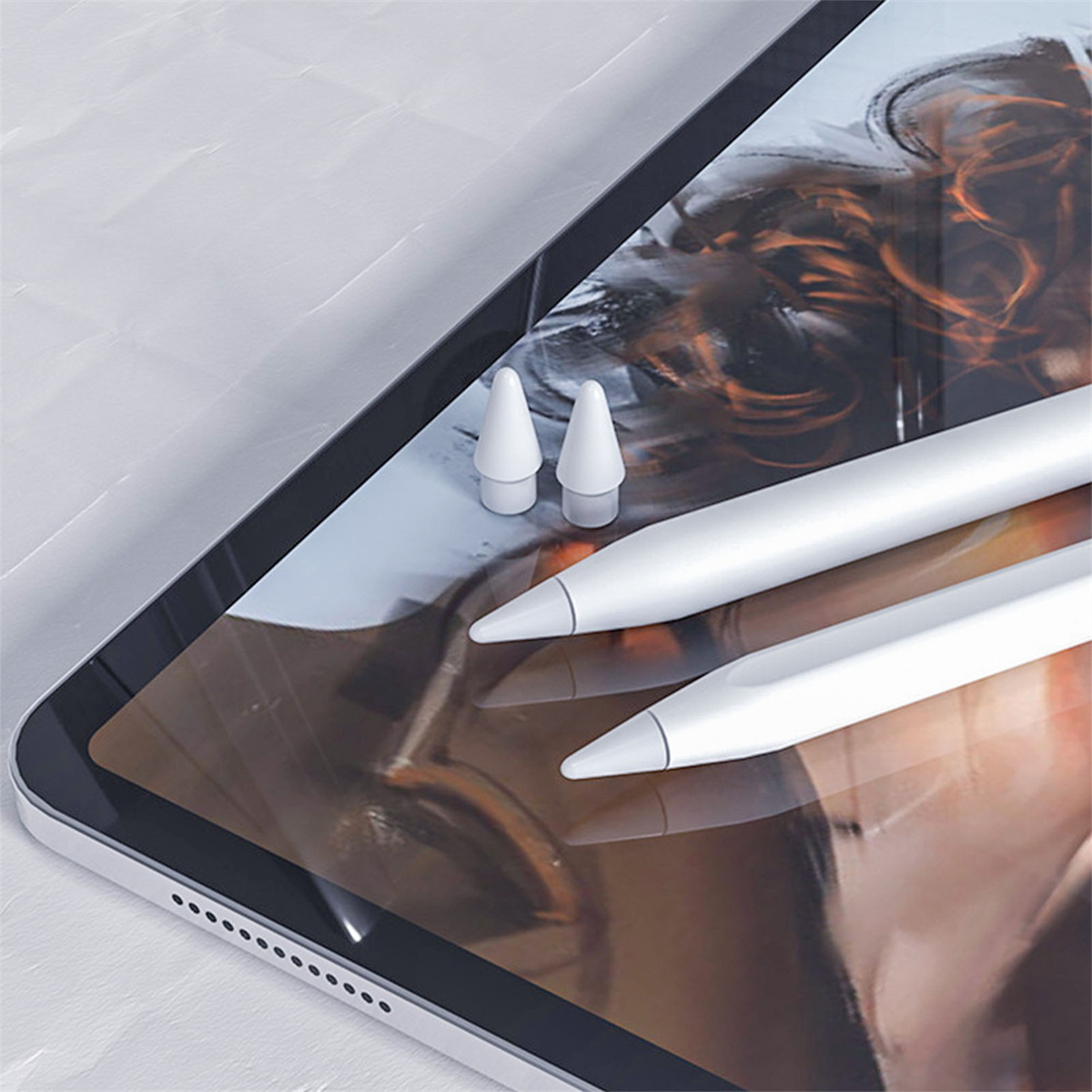 Weißes iPad mit zwei weißen Apple Pencils. Die Stifte befinden sich in der Nähe des Bildschirms.
