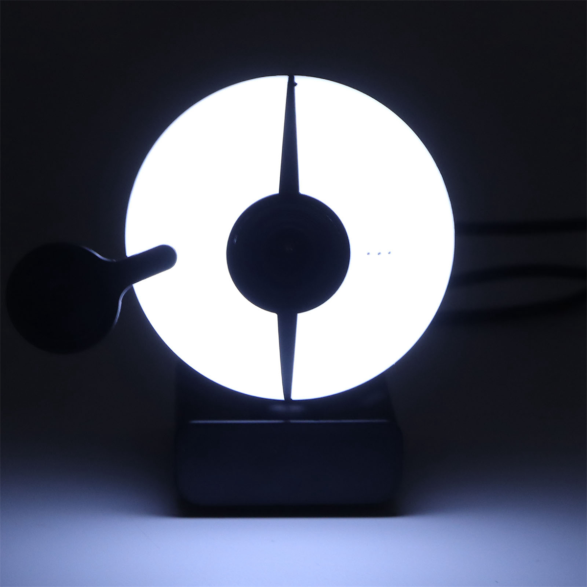 Ein beleuchtetes, weißes kreisförmiges Licht. Schwarzer Hintergrund.