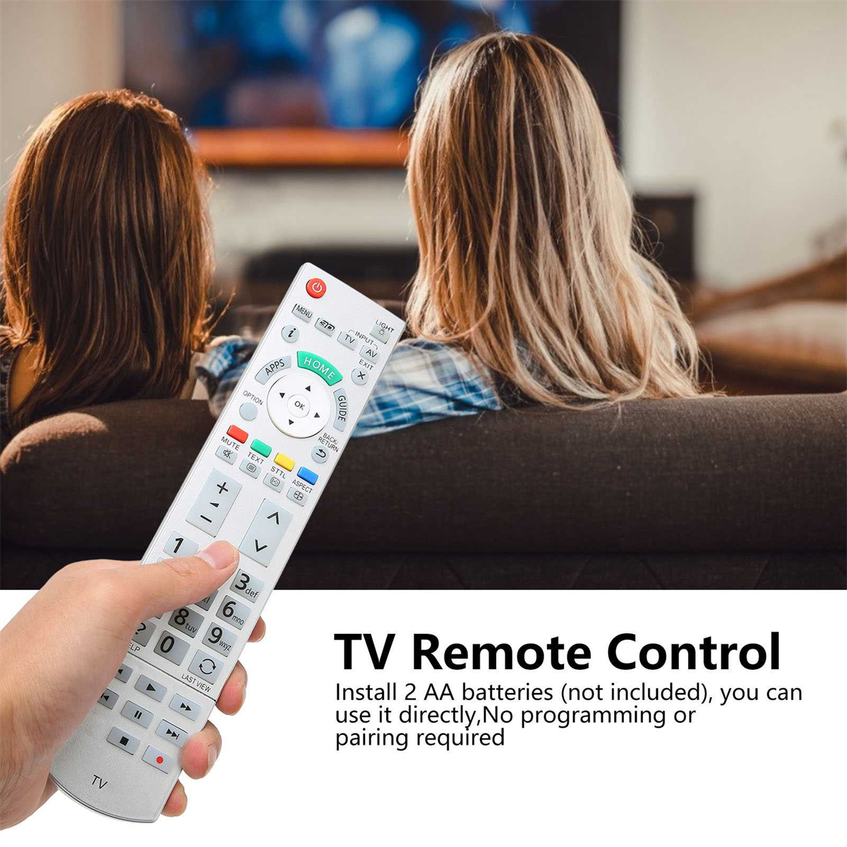 Hand, die eine weiße TV-Fernbedienung hält. Im Hintergrund zwei Frauen auf einem Sofa.