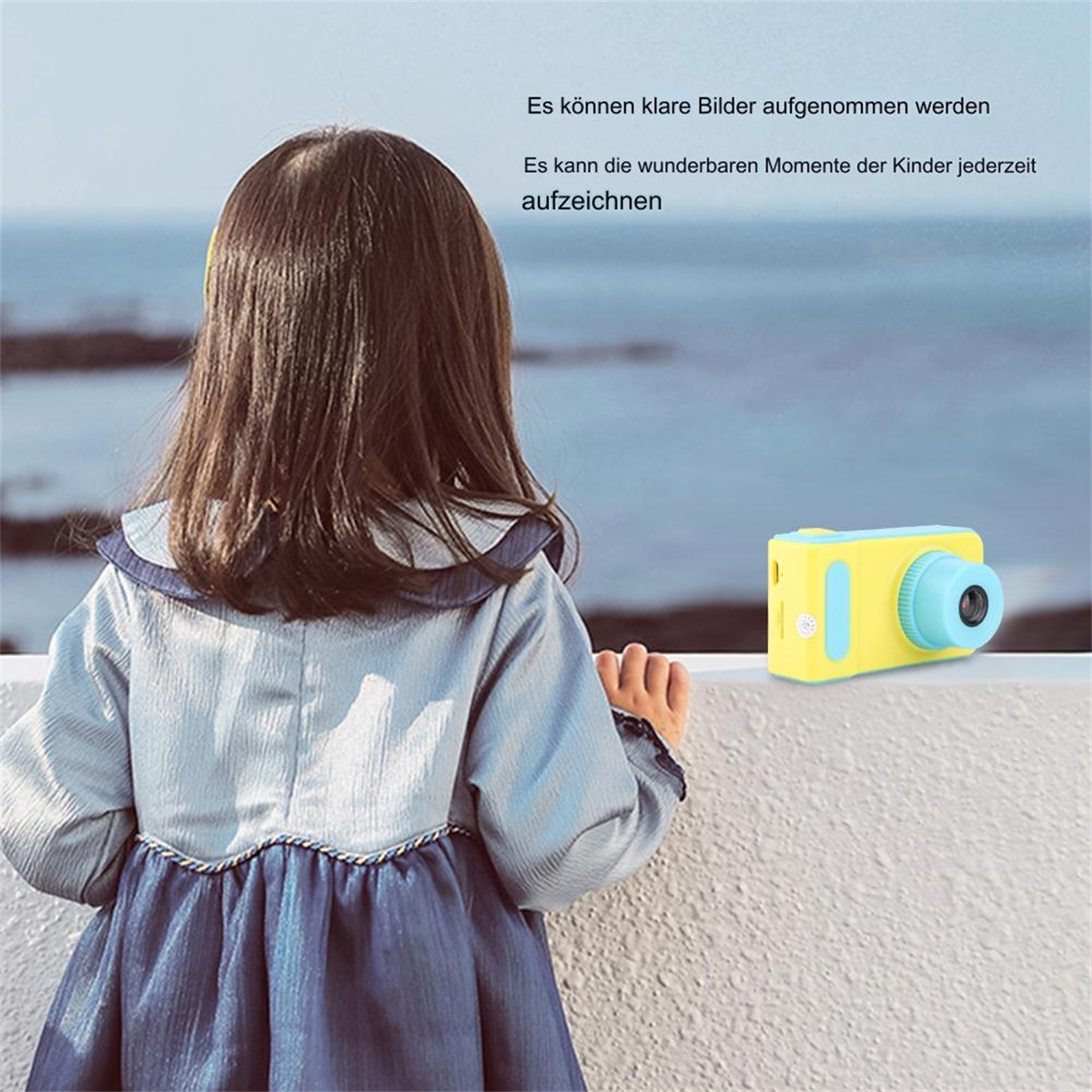 Ein Mädchen, das das Meer betrachtet und eine gelb-blaue Kamera. Text auf Deutsch.