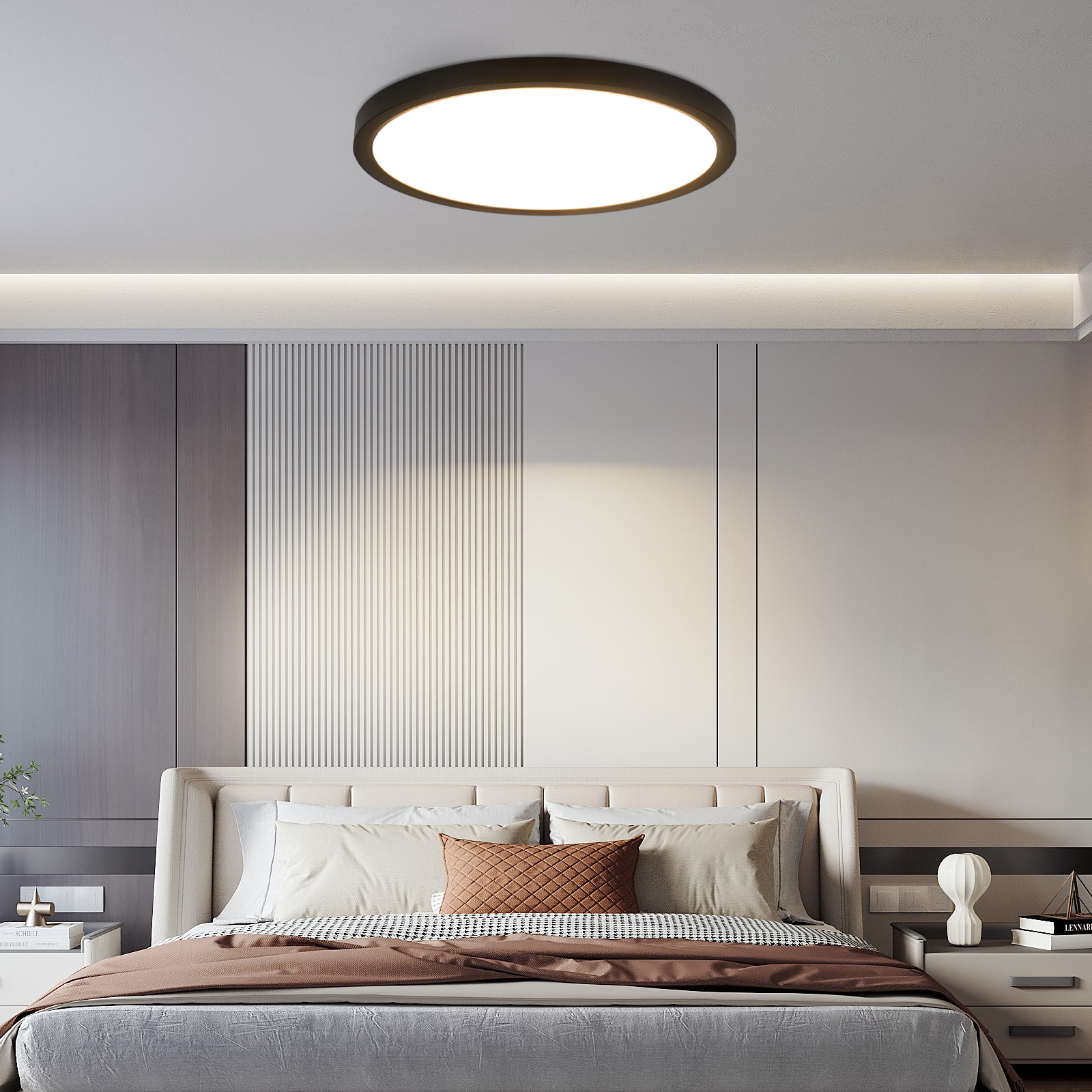 Lampada da soffitto rotonda sopra un letto con cuscini e copriletto marrone.