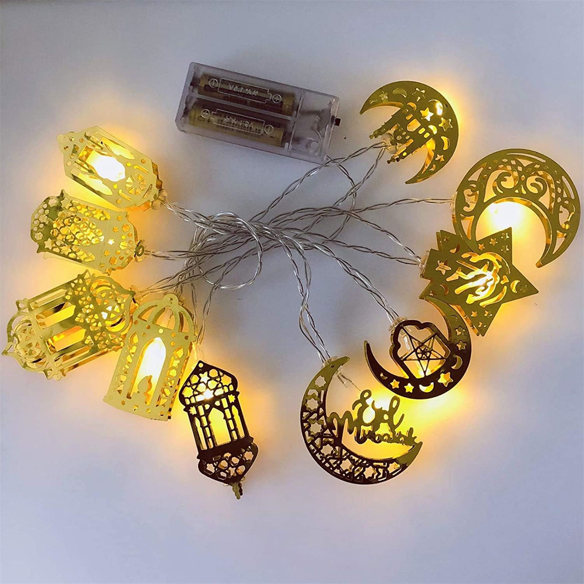 Eine Lichterkette mit goldenen Dekorationslichtern mit Laternen und Mondformen auf weißem Untergrund.