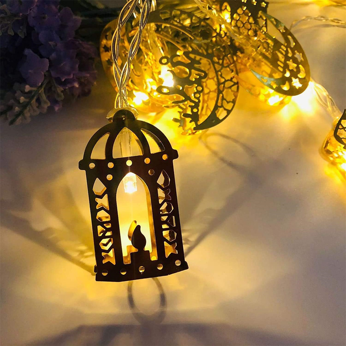 Dekorative Lichterkette mit kerzenförmigen Laternen und goldenen Lichtern.