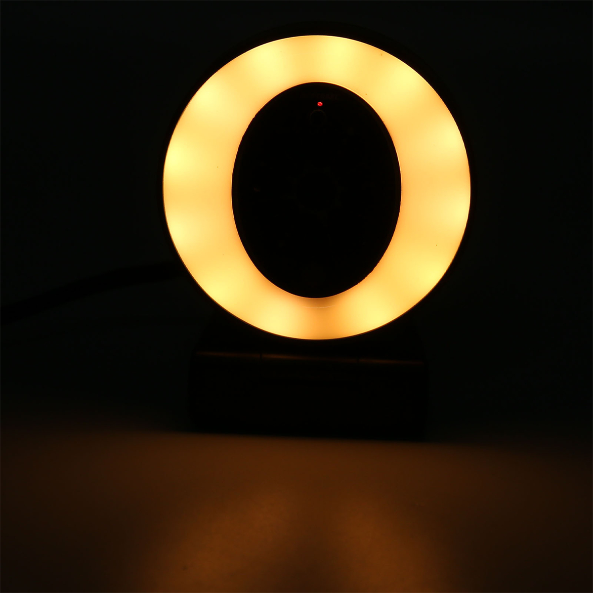 Nahaufnahme eines Ringlichts, das ein weiches gelbes Leuchten vor dunklem Hintergrund aussendet.