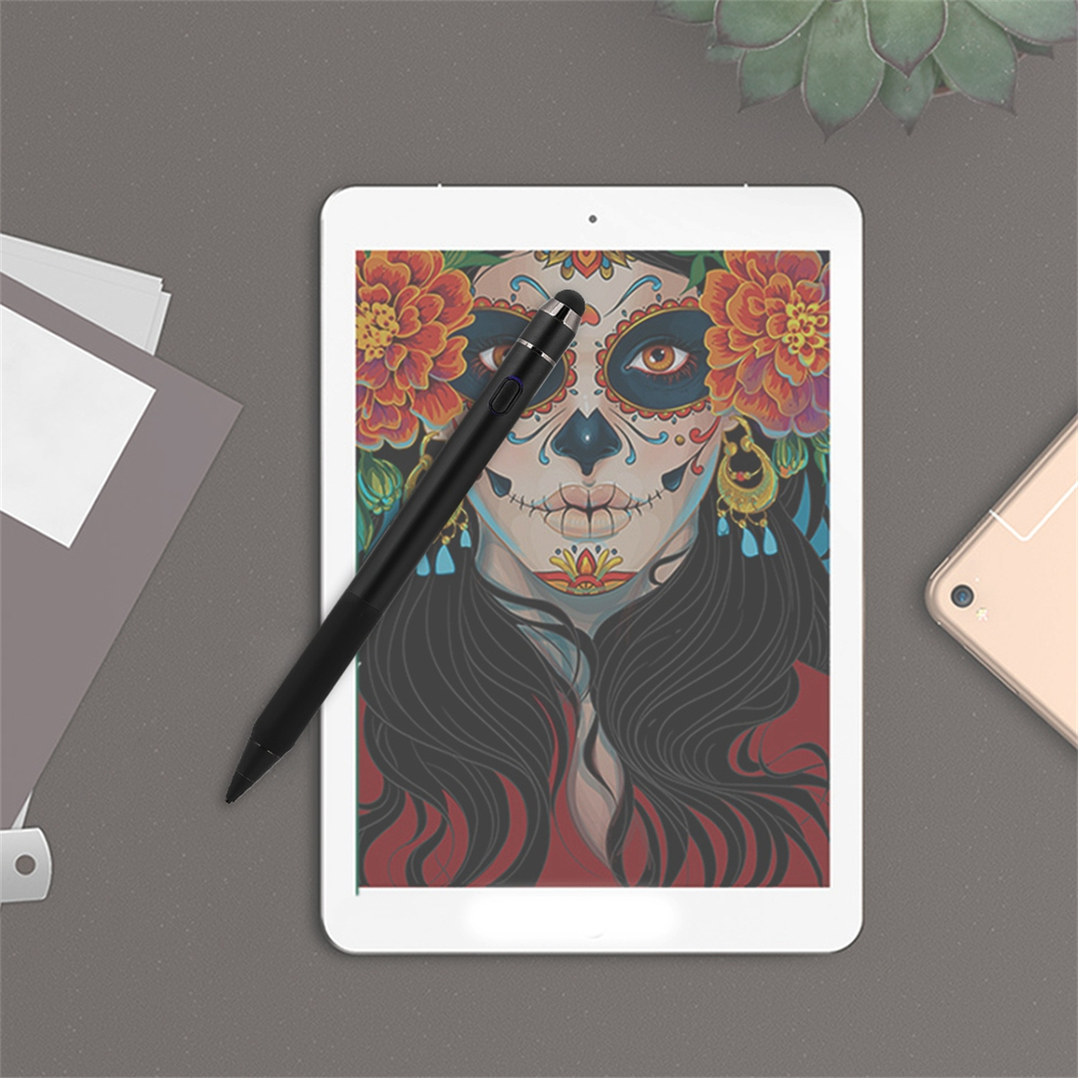 Tablet mit farbenfroher Gesichts-Kunst, schwarzem Stift und Telefon, auf grauer Oberfläche.