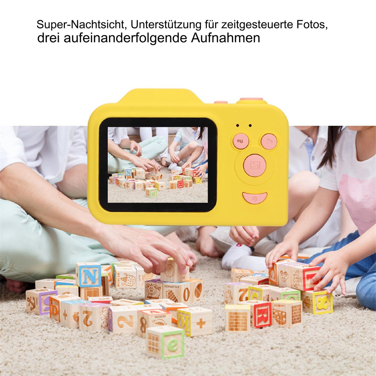 Gelbe Kamera, die einen Bildschirm mit Kindern zeigt, die mit Blöcken spielen. Hände im Vordergrund, Blöcke in der Mitte.