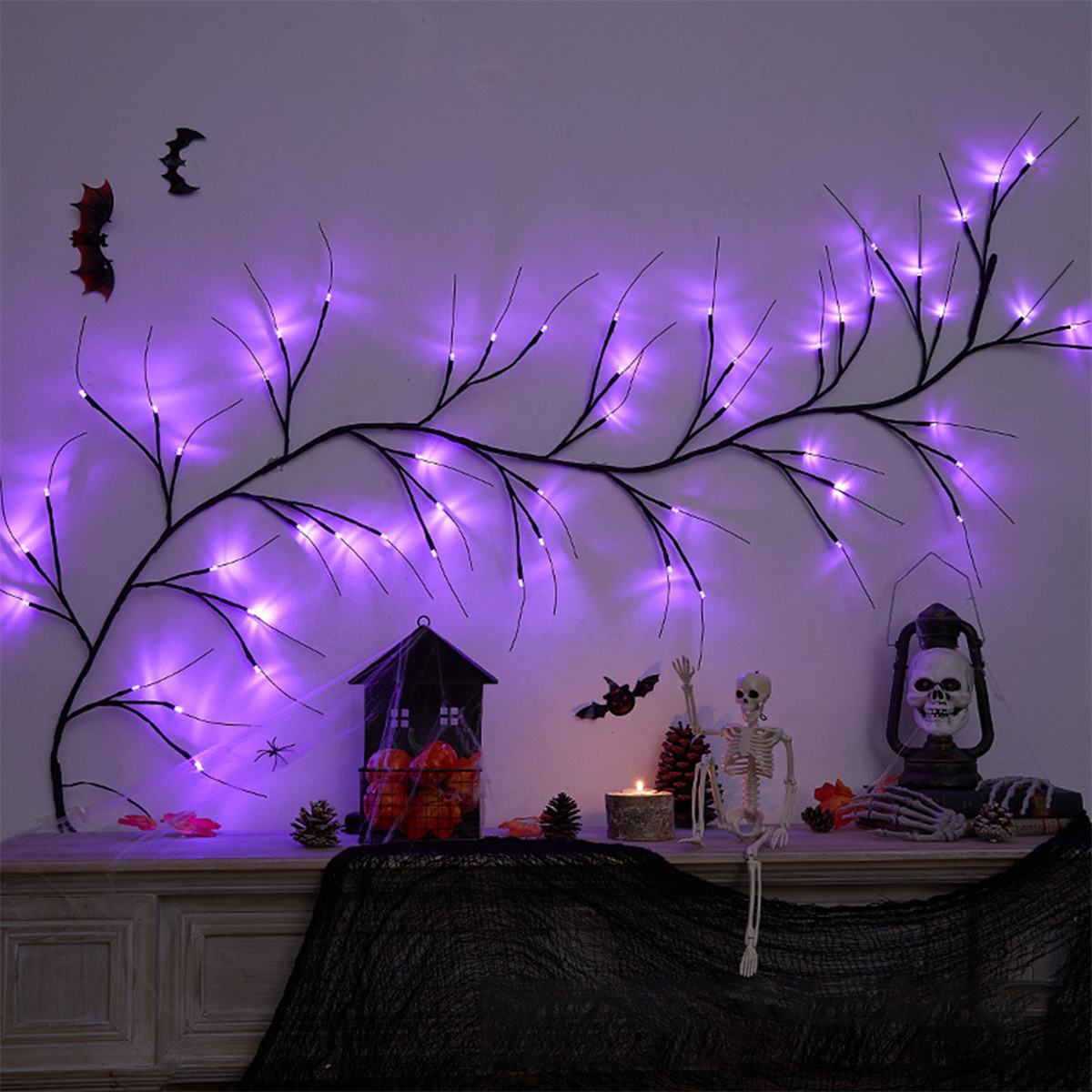 Halloween-Szene: Ein Baum mit lila Lichtern, Dekorationen, einem Skelett und einer Laterne.