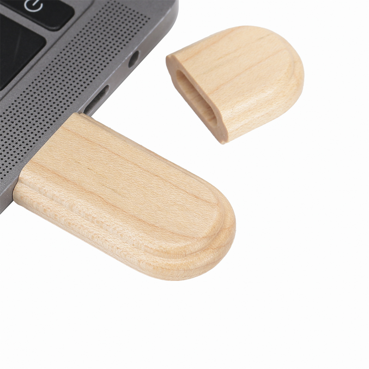 Ein USB-Stick aus Holz, der in einen Laptop gesteckt ist.