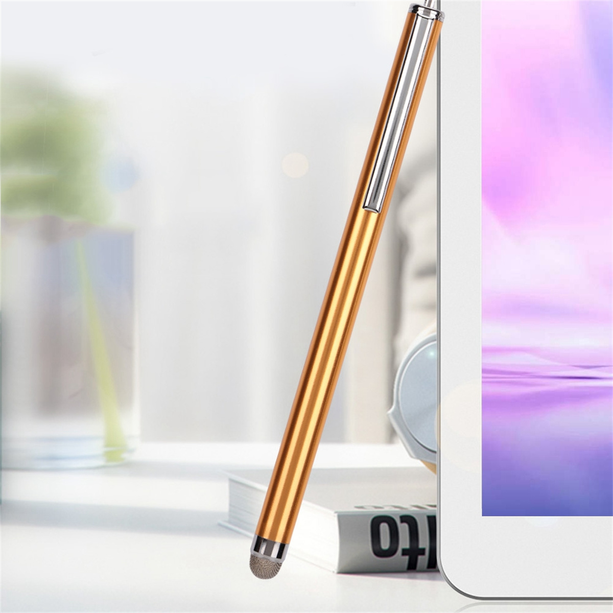 Ein goldener Eingabestift neben einem Tablet. Der Stift ist dünn und hat eine silberne Spitze.