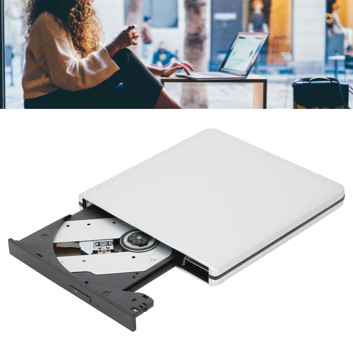Weißes tragbares DVD-Laufwerk mit Laptop im Hintergrund. Eine Person arbeitet.