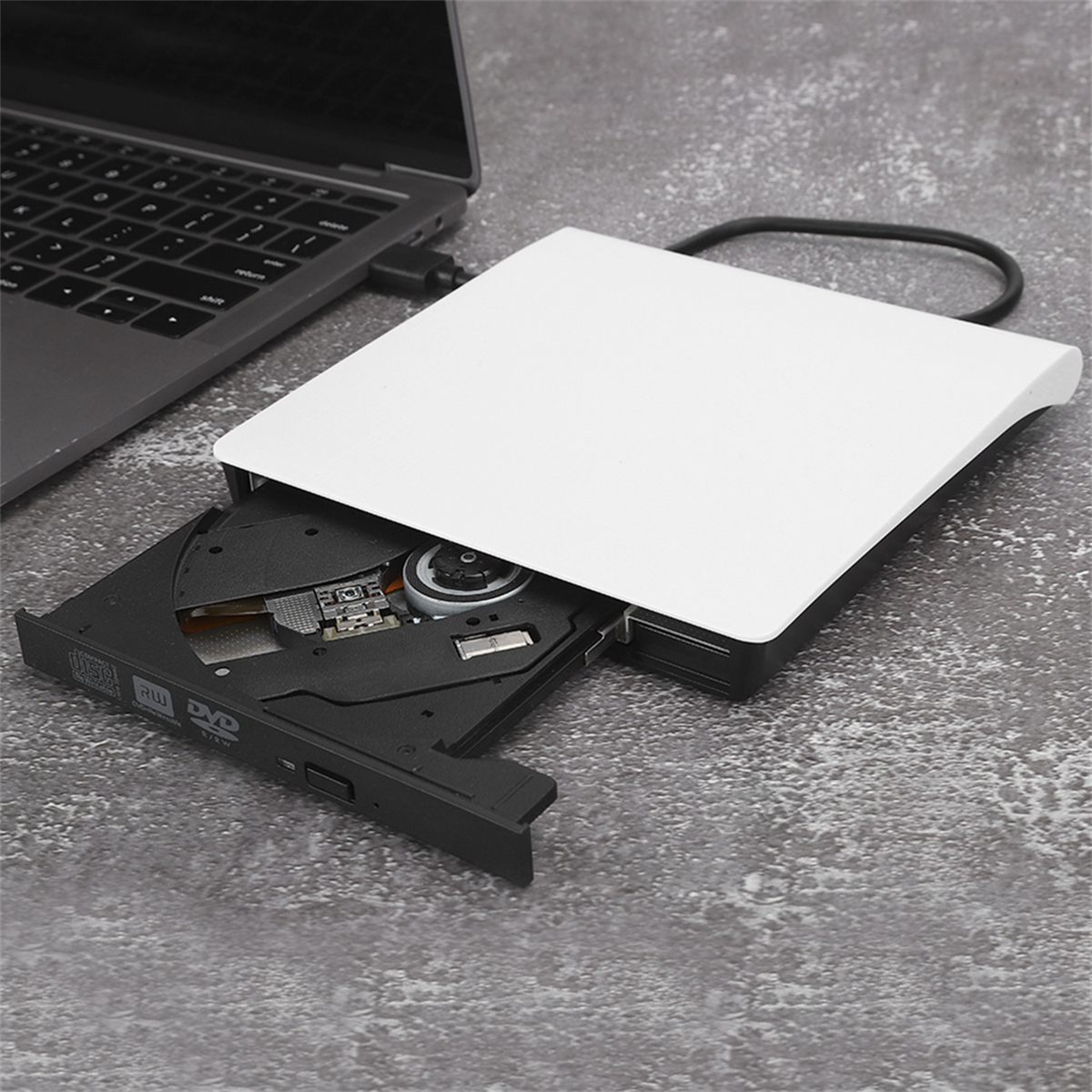 Laptop und externes DVD-Laufwerk. Das Fach ist geöffnet und eine Disc ist drin.