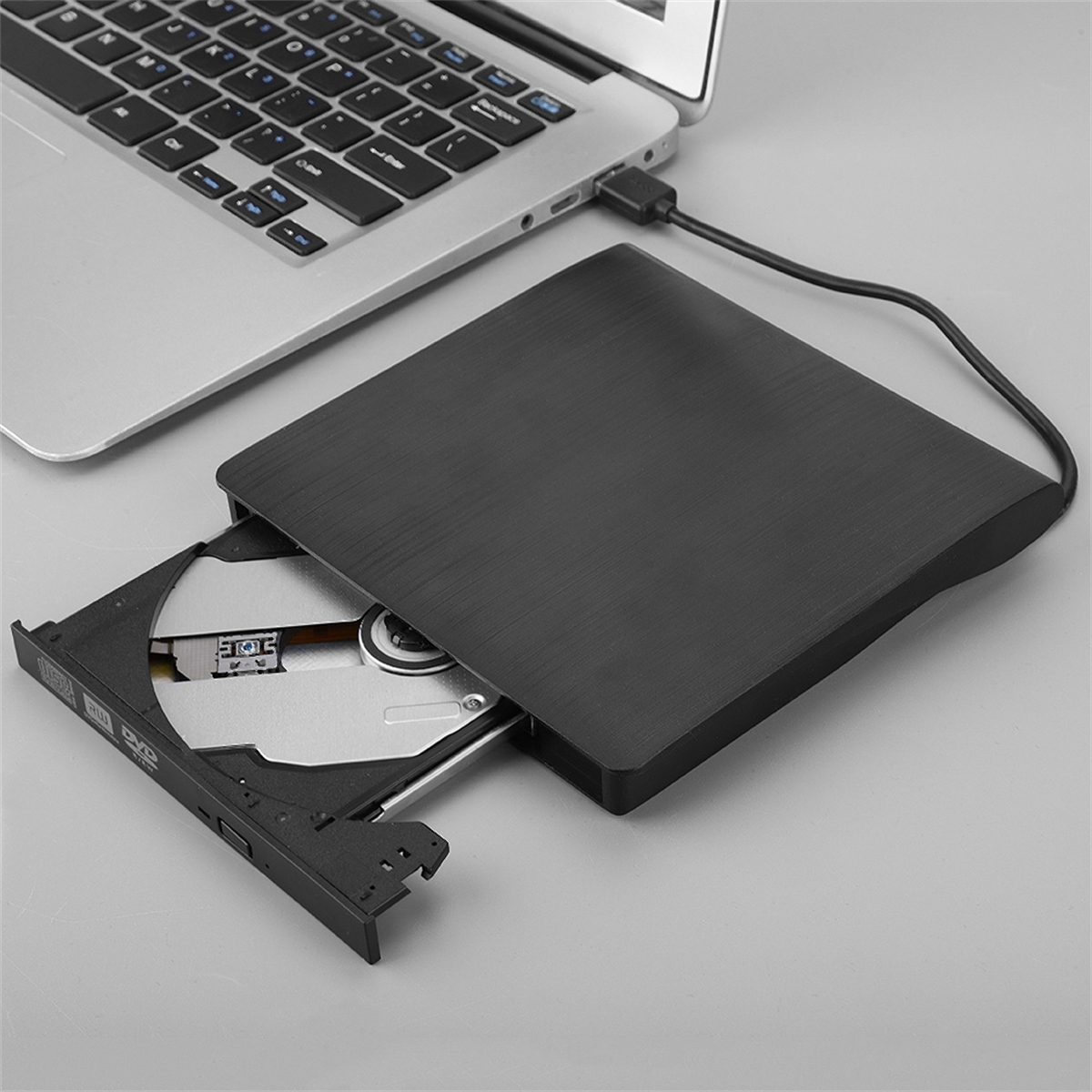 Ein Laptop mit einem DVD/CD-Laufwerk, das angeschlossen und geöffnet ist. Das Laufwerk ist schwarz.