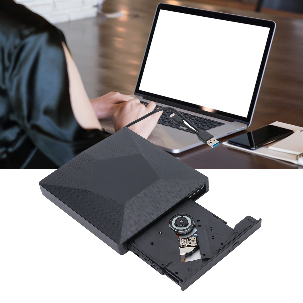Ein Laptop befindet sich über einem schwarzen DVD-Laufwerk. Eine Person arbeitet an dem Laptop.
