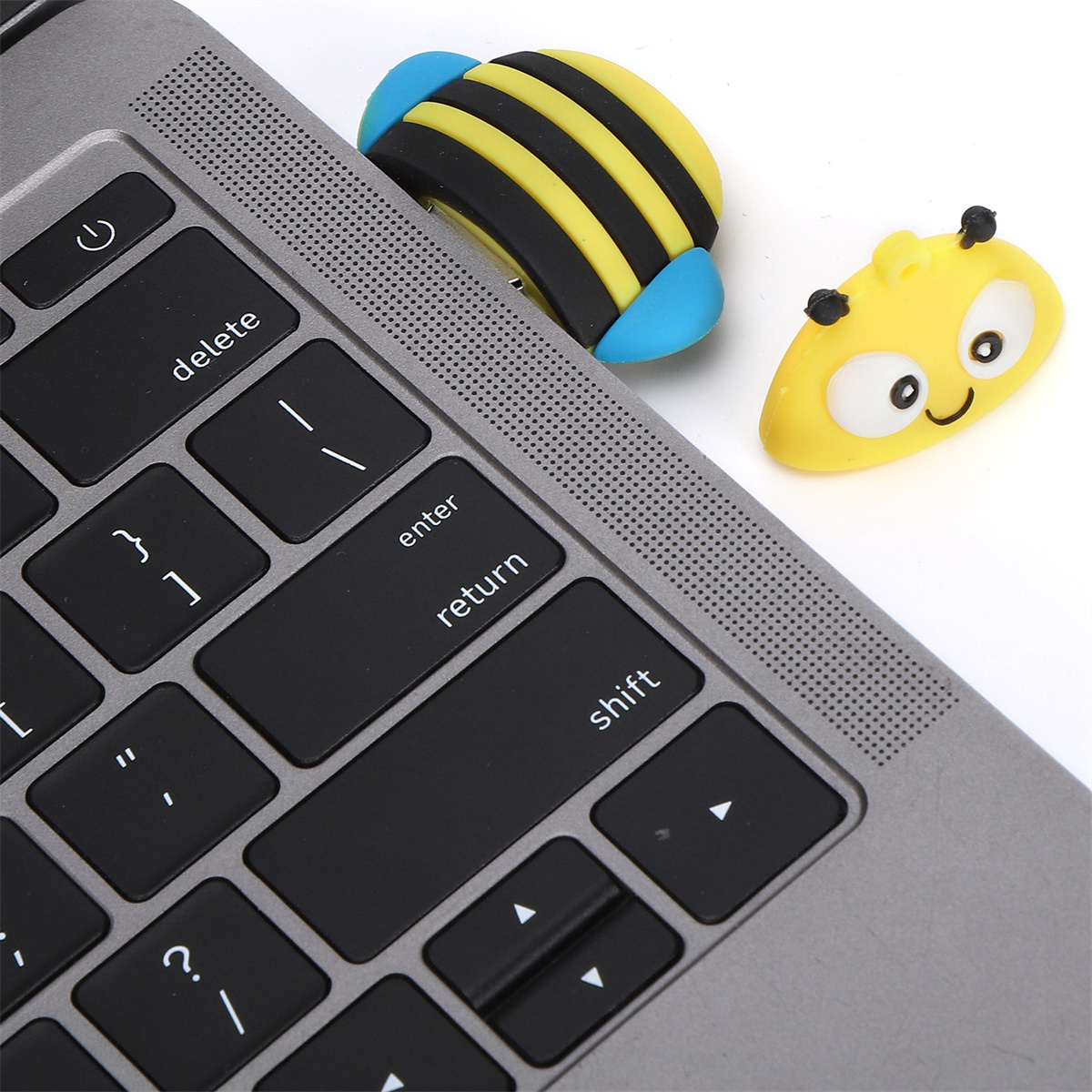 Laptop-Tastatur mit zwei bienenförmigen Aufklebern auf den Tasten, einem auf der Eingabetaste.