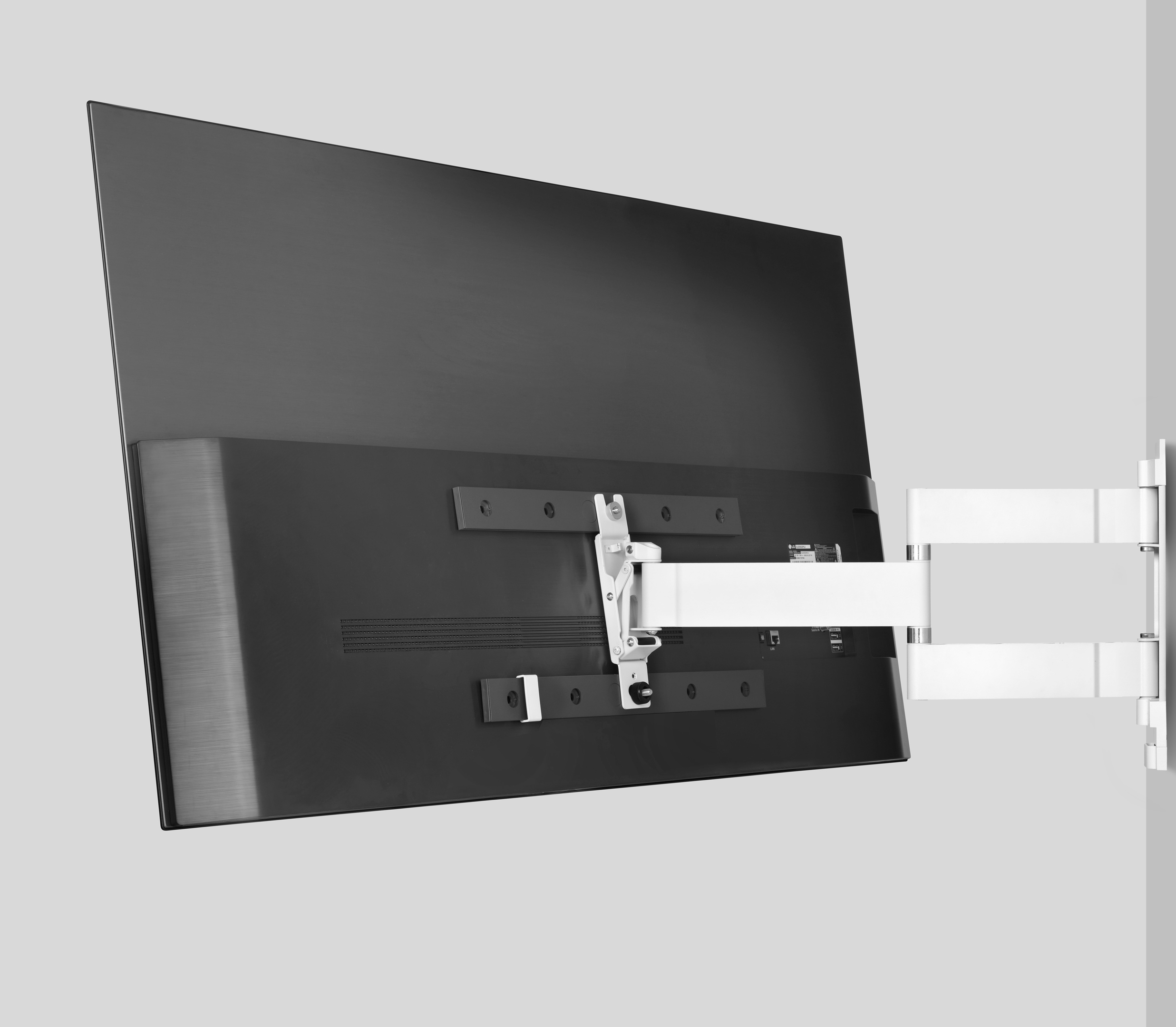 Großer schwarzer Fernseher an einer weißen Wandhalterung befestigt. Rückansicht des Fernsehers ist sichtbar.