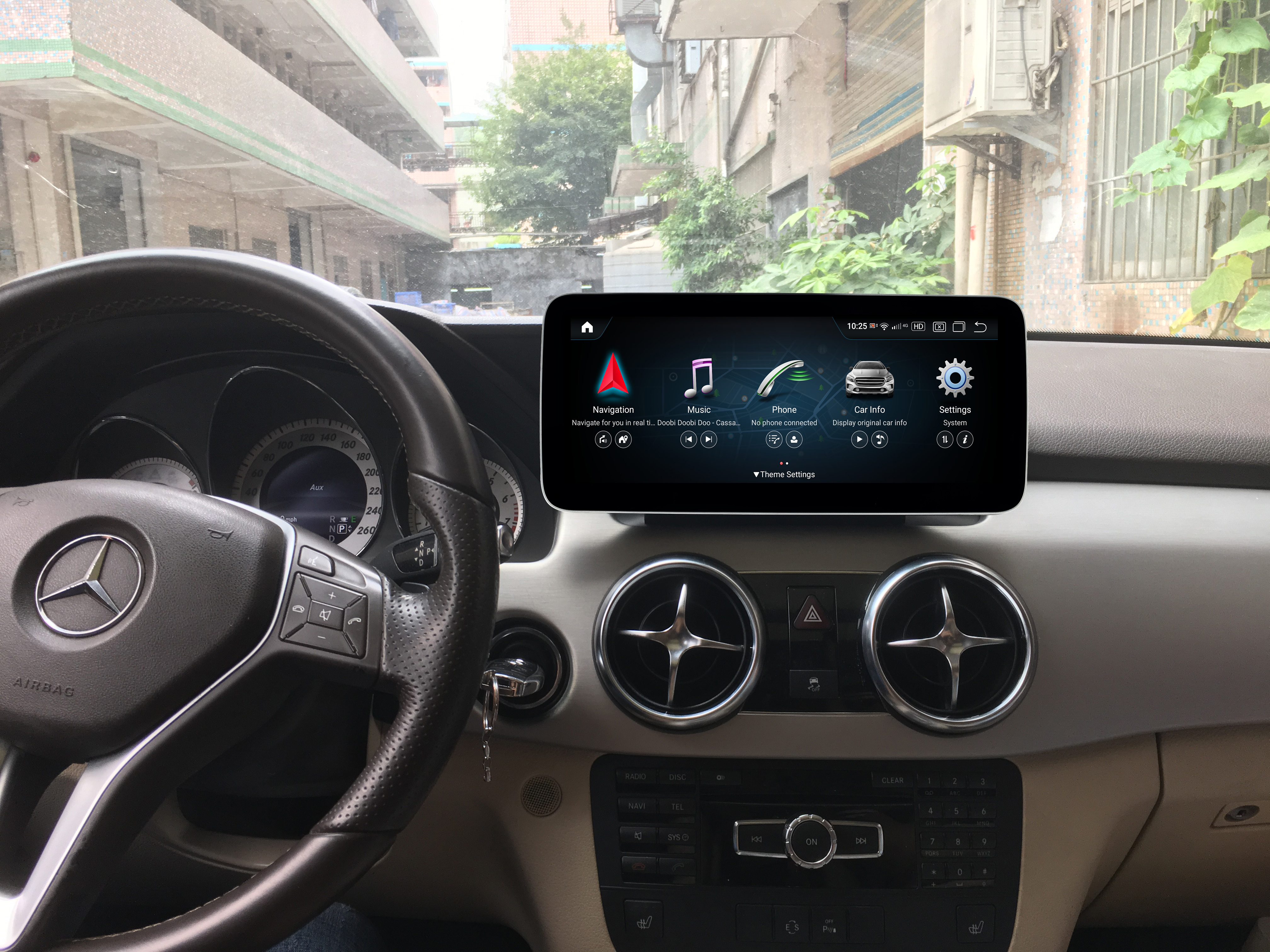 Der Innenraum eines Autos. Das Armaturenbrett des Autos zeigt einen Bildschirm mit Navigation und Musik.