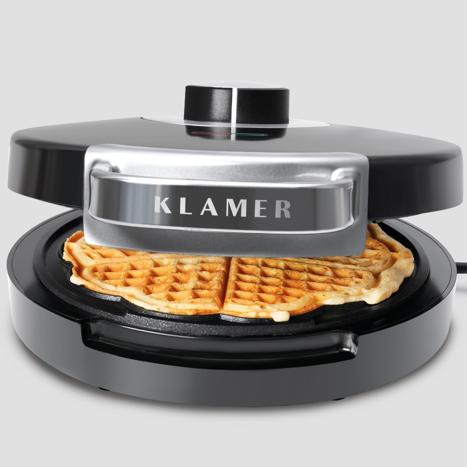 Schwarzer Waffeleisen mit Waffel, Deckel offen, auf weißer Oberfläche.
