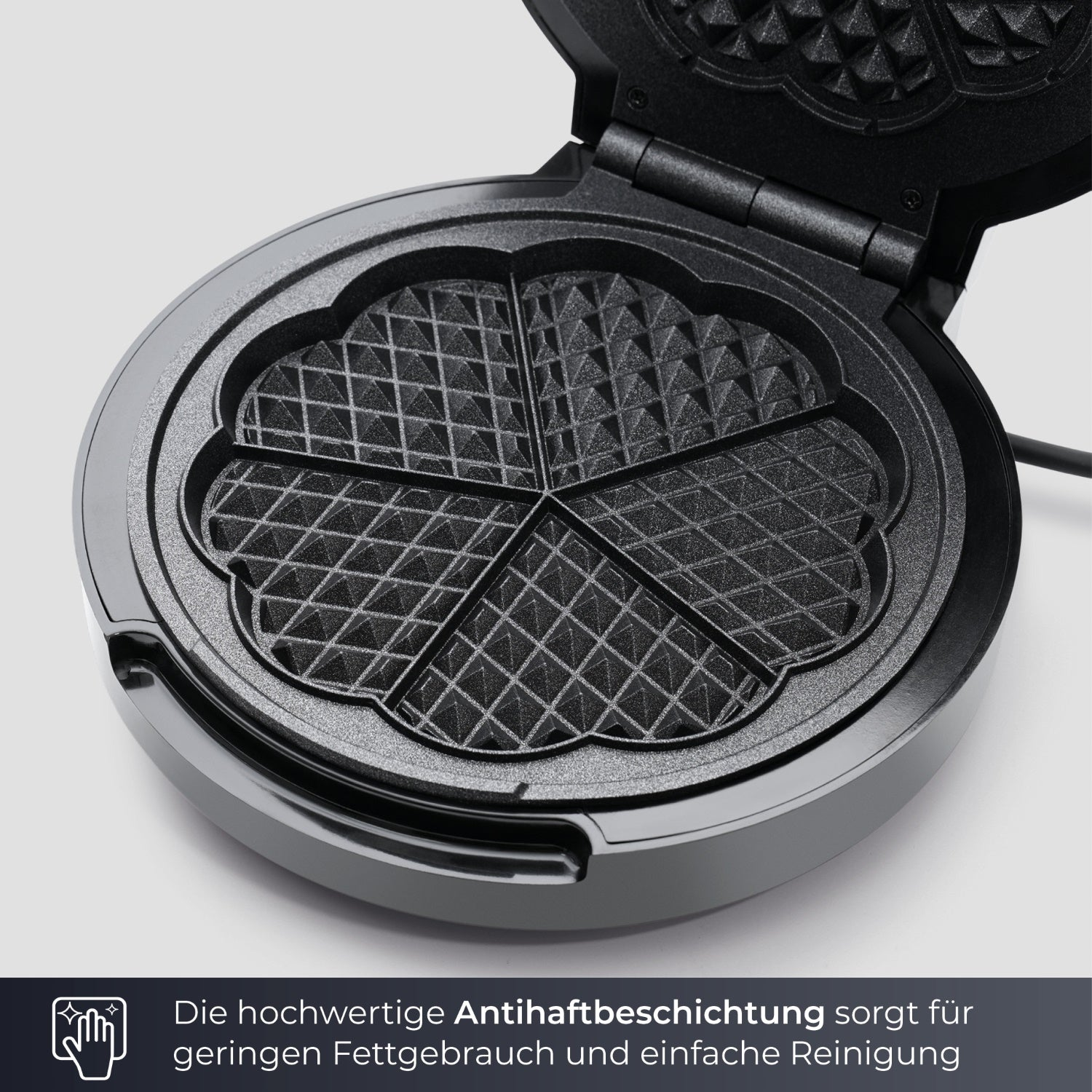 Ein Waffeleisen mit fünf herzförmigen Formen. Der Hintergrund ist eine hellgraue Oberfläche.