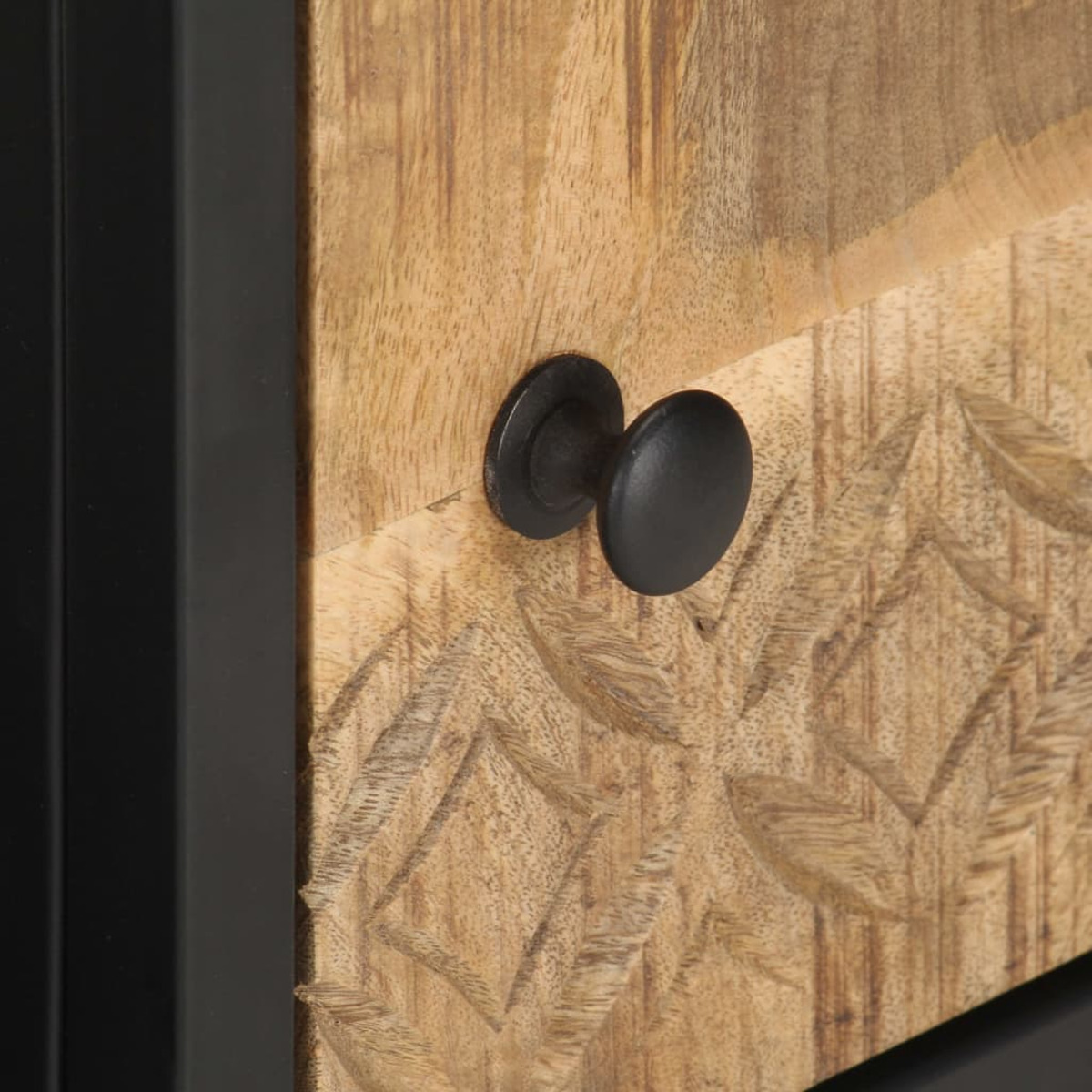Nahaufnahme einer Holzschublade mit schwarzen Knöpfen. Die Schublade hat geschnitzte Muster.