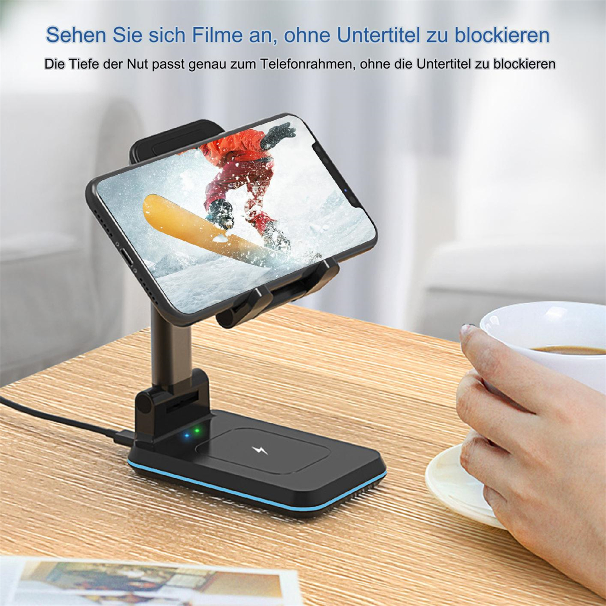 Ein Telefon auf einem Ständer, kabellos ladend, mit einer Person, die eine Tasse hält.