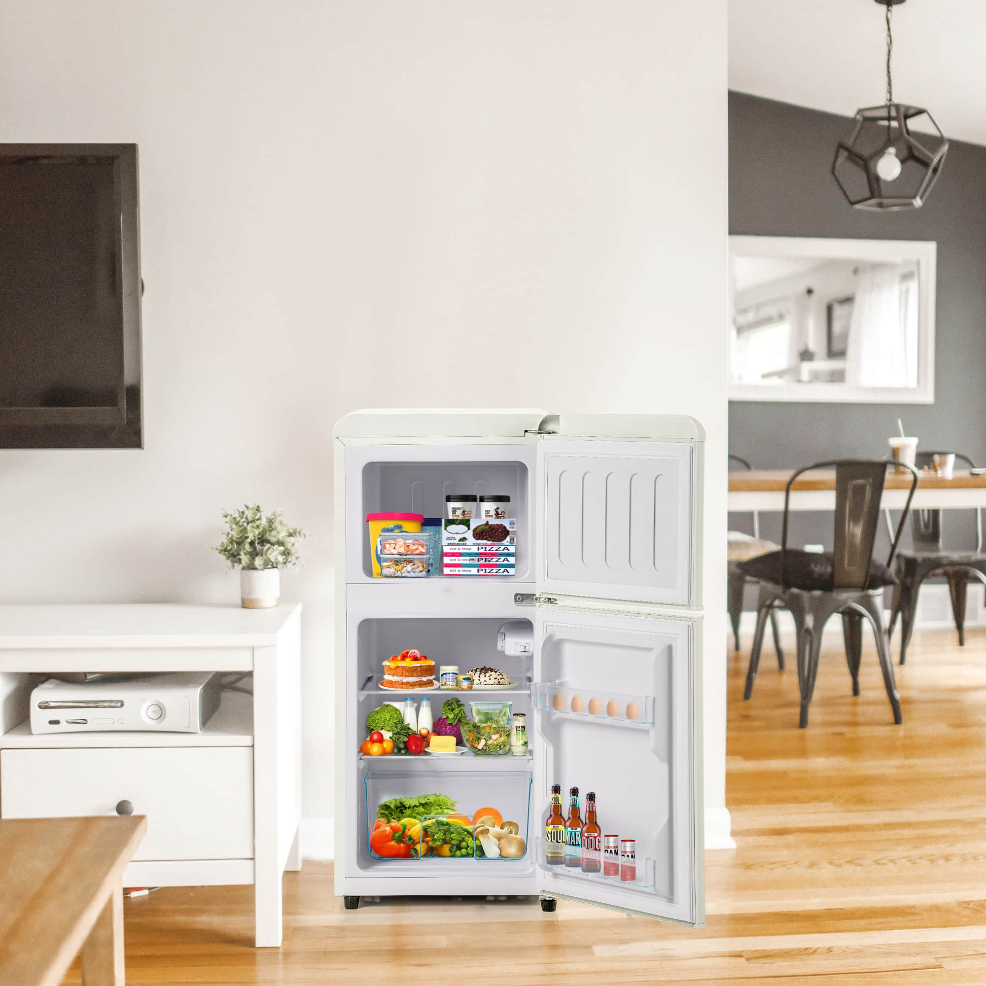 Weißer Kühlschrank mit offenen Türen, Inhalt Lebensmittel. Wohnzimmer im Hintergrund.