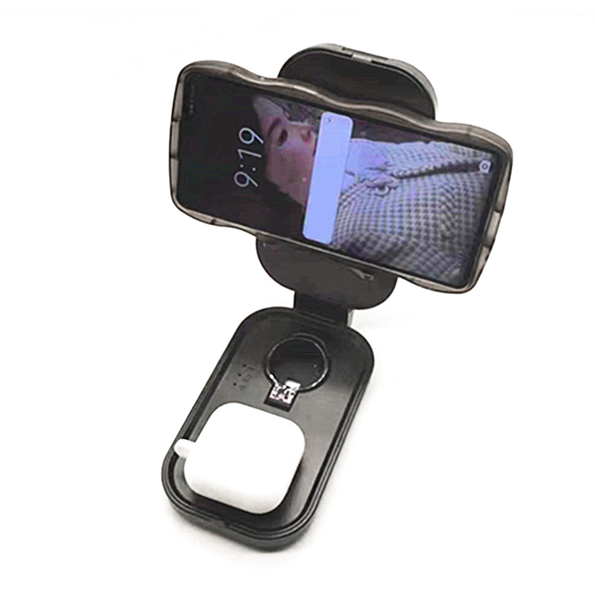 Ein schwarzer Telefonhalter mit einem Telefon, das einen Sperrbildschirm anzeigt, und einem geöffneten Etui mit weißen Ohrhörern.