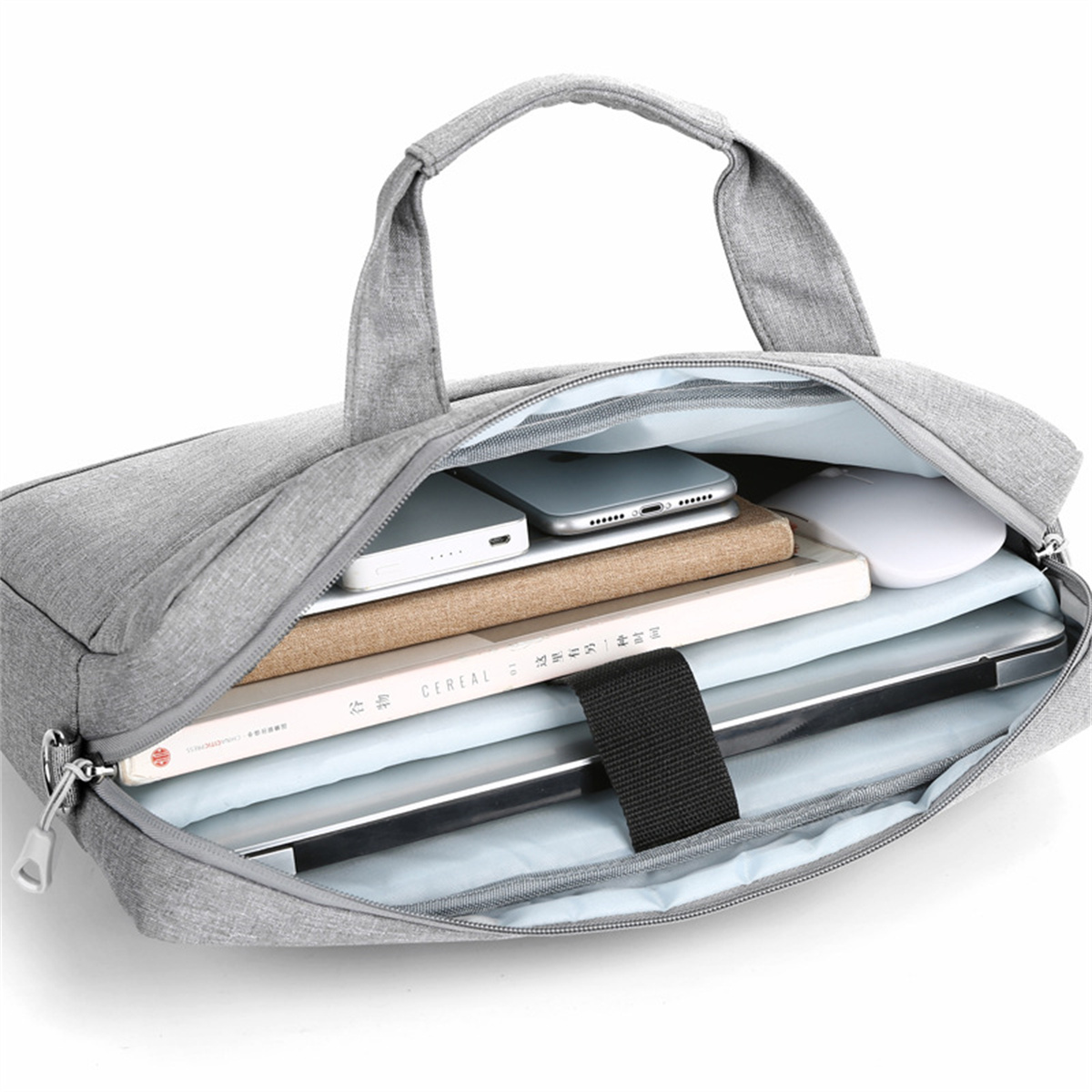 Eine graue Laptoptasche, offen, mit Laptop, Buch, Telefon und Zubehör darin.