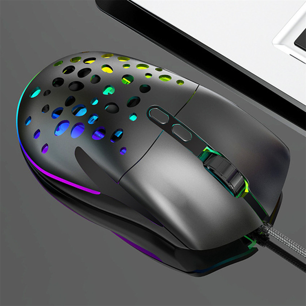 Eine schwarze Gaming-Maus mit RGB-Beleuchtung und Wabenmuster auf einer reflektierenden Oberfläche.
