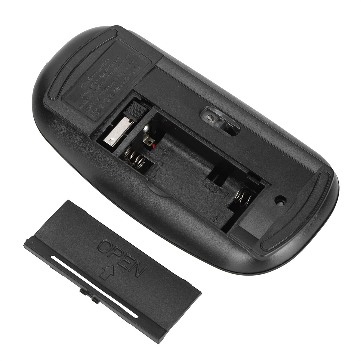 Die Unterseite einer schwarzen Computermaus mit geöffnetem Batteriefach und Batterie.