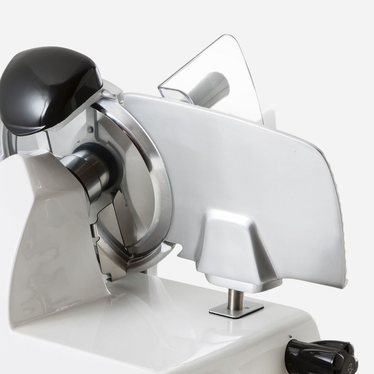 Srebrna krajalnica do mięsa na białej powierzchni. Ma ostrze, uchwyt i czarne pokrętło.