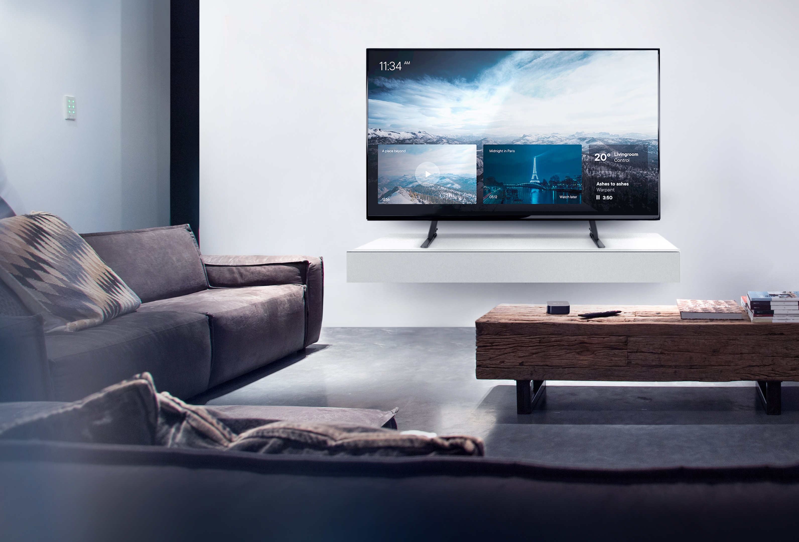 Wohnzimmer mit Fernseher, der eine Smart-Oberfläche zeigt, Sofa und Holztisch.