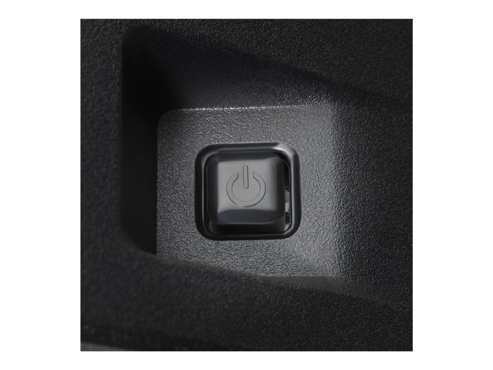 Zbliżenie czarnego przycisku zasilania na ciemnoszarej powierzchni.