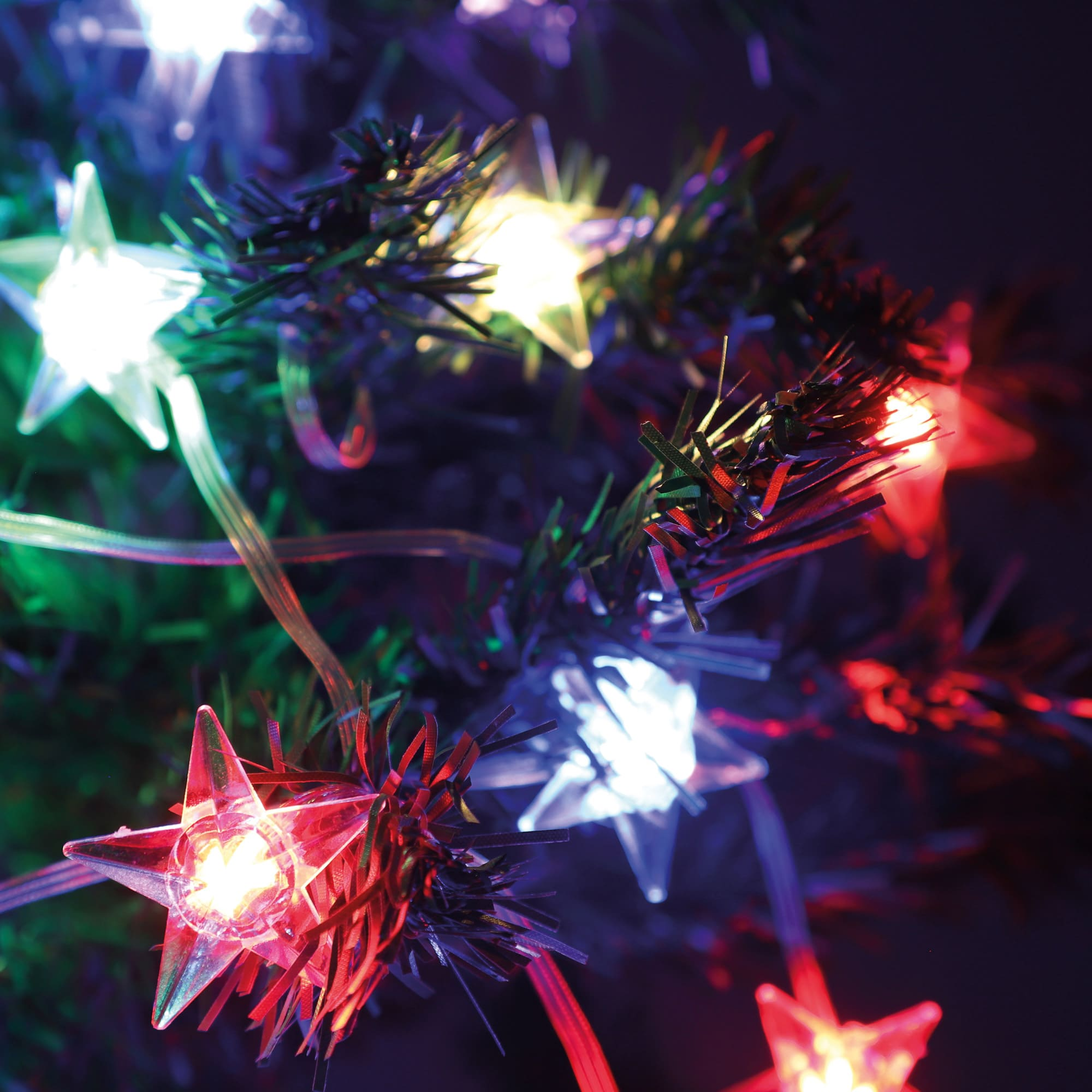 Zbliżenie światełek choinkowych z żarówkami w kształcie gwiazd w różnych kolorach.