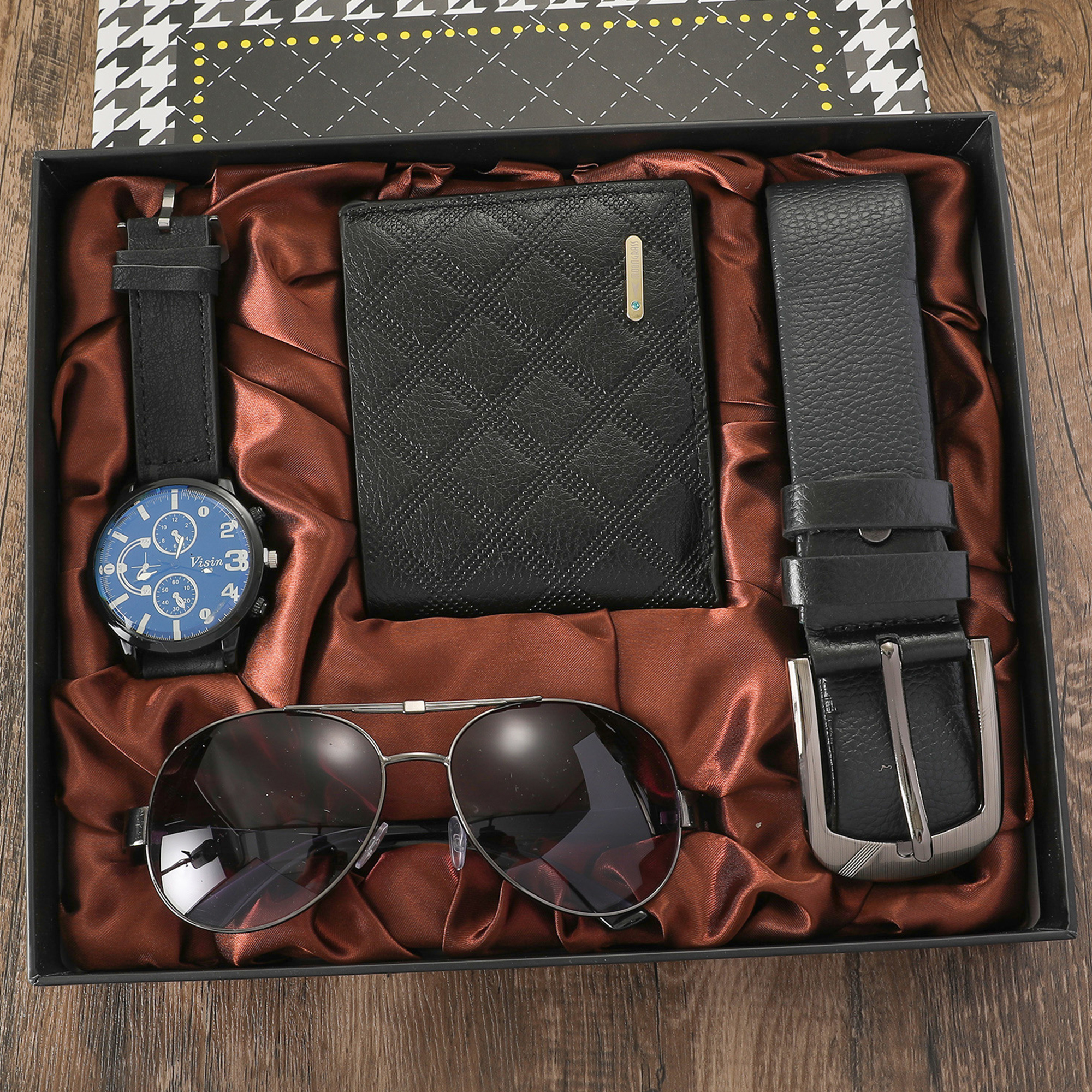 Geschenkbox-Set mit Uhr, Brieftasche, Sonnenbrille und Gürtel auf einem braunen, seidenartigen Stoff.