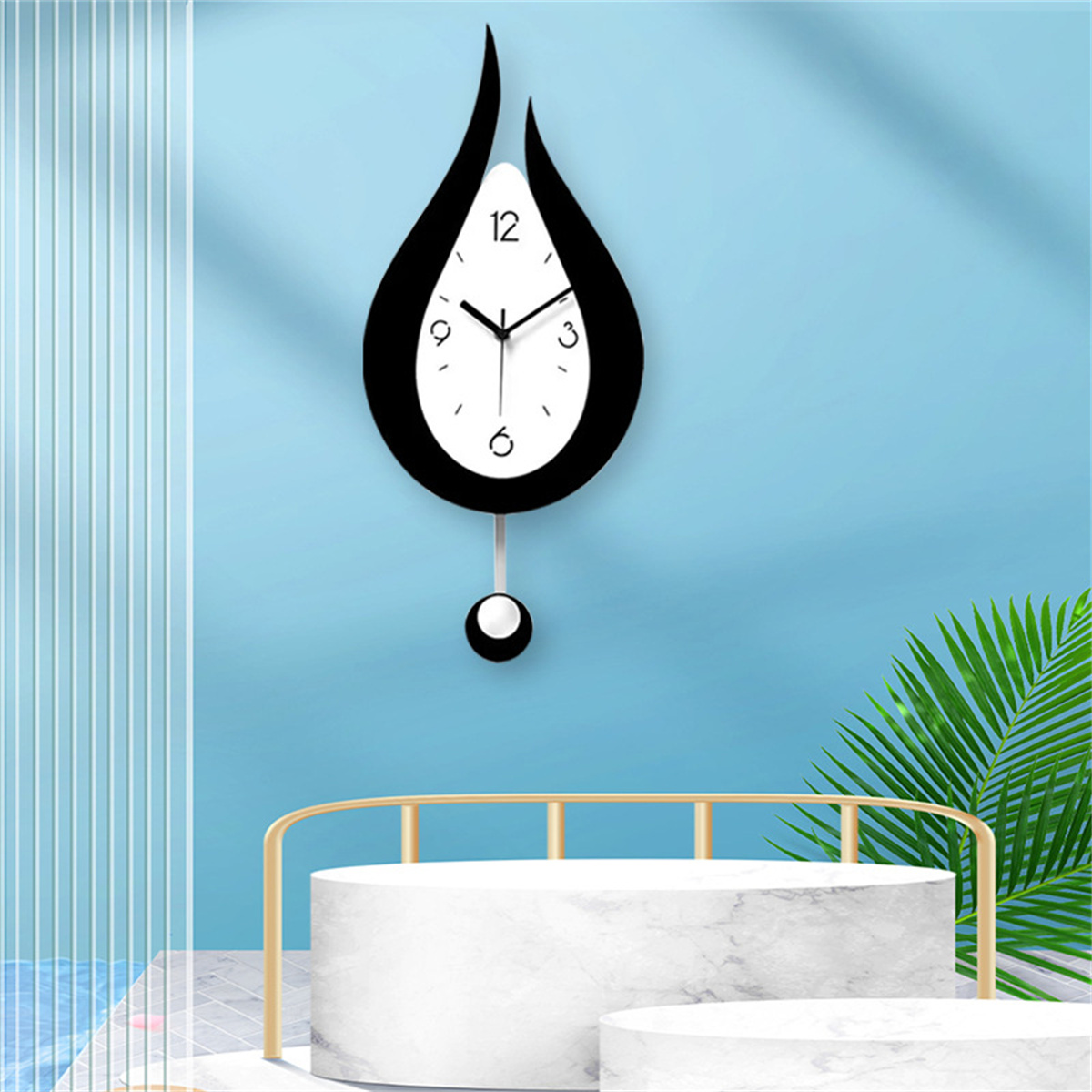 Eine schwarz-weiße tropfenförmige Wanduhr mit Pendel an einer blauen Wand.