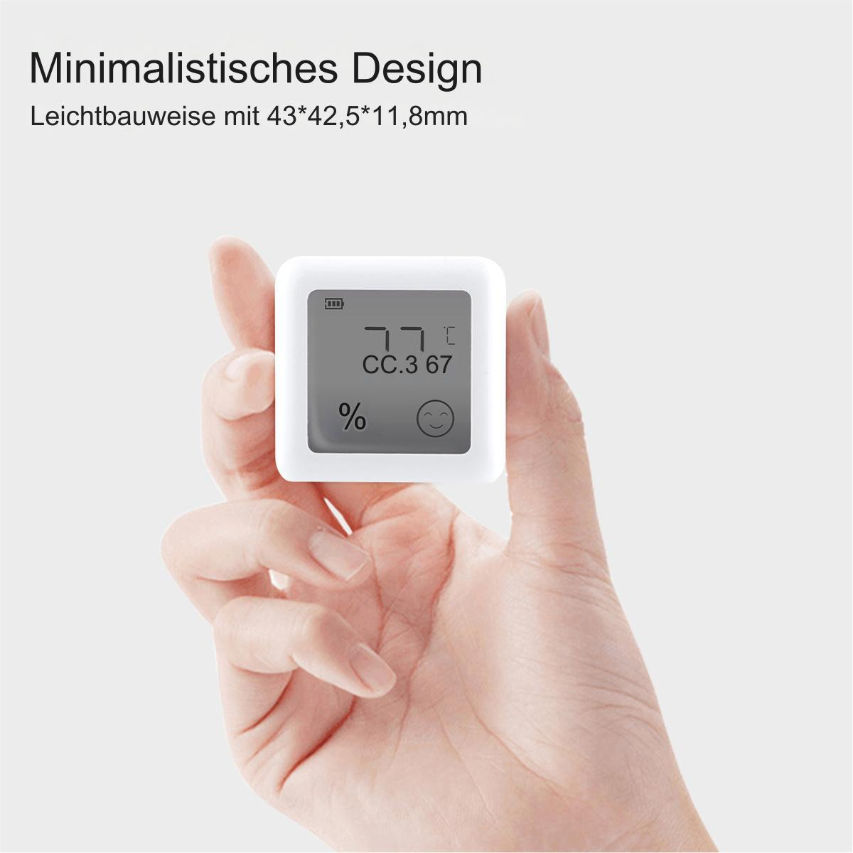 Eine Hand, die ein kleines weißes digitales Gerät mit Zahlen und einem Smiley hält.
