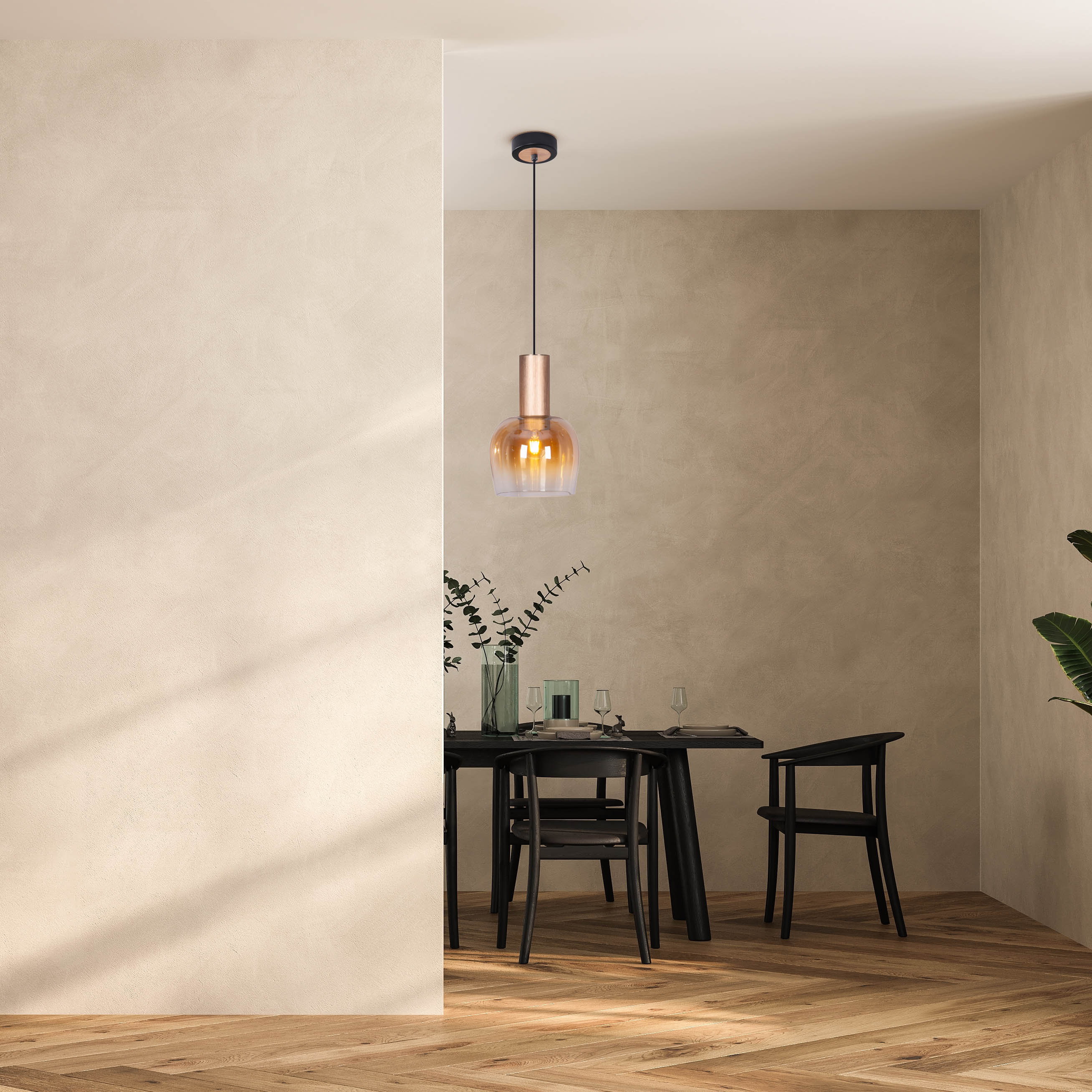 Eine Hängelampe mit einem klaren und bernsteinfarbenen Glasschirm. Im Esszimmer.