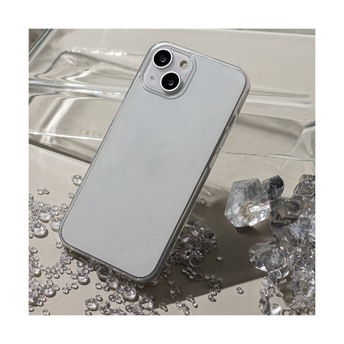 Uno smartphone con custodia trasparente, circondato da cristalli, su una superficie riflettente.
