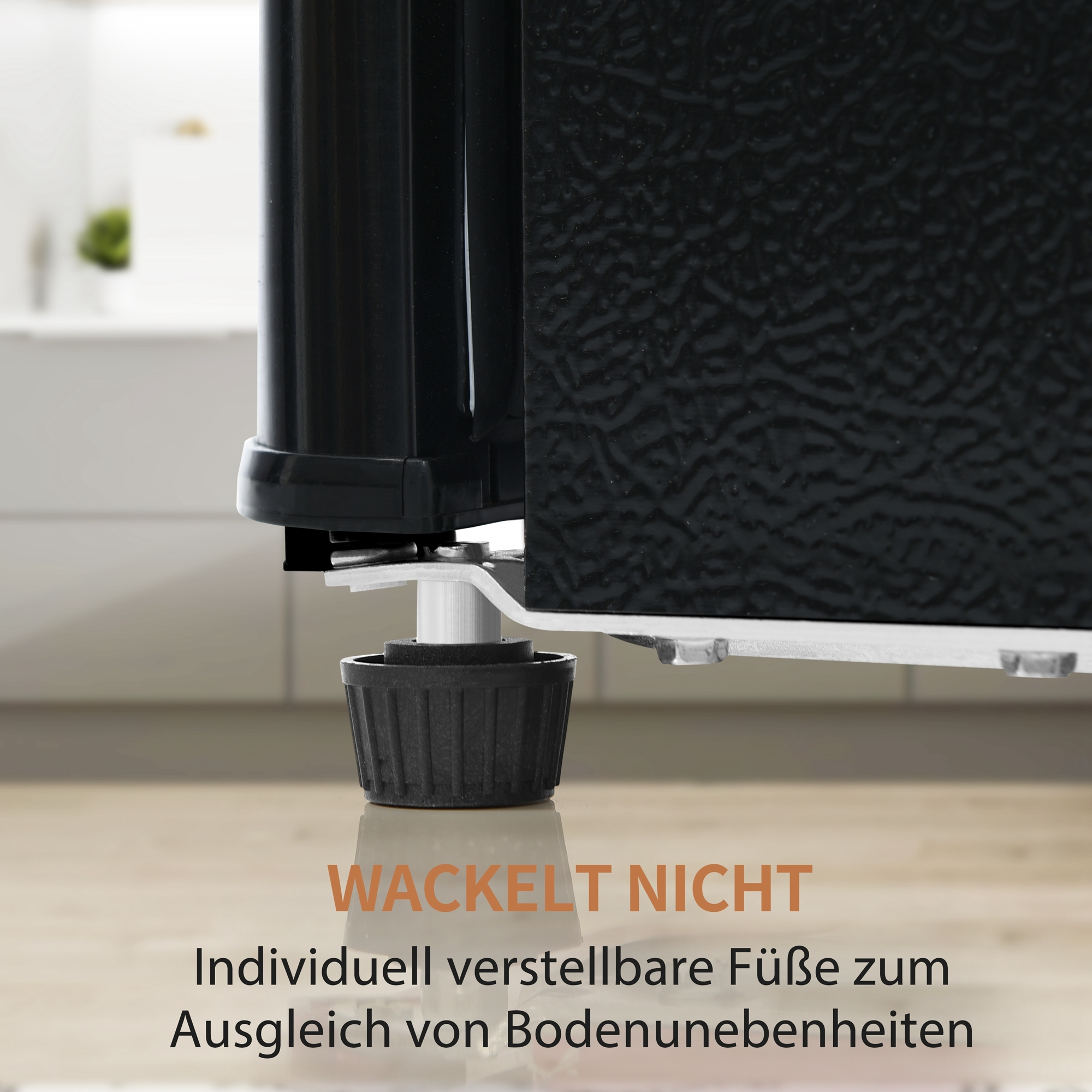 Nahaufnahme eines schwarzen Kühlschrankfußes. Der Text lautet: Wackelt nicht. Verstellbare Füße.