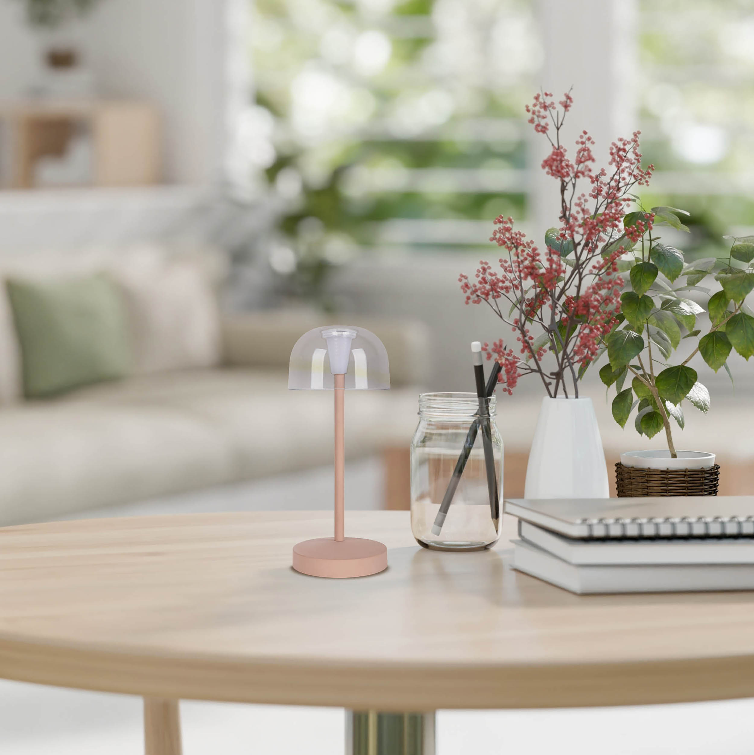 Tavolo con lampada, fiori, barattolo e libri. Soggiorno sfocato sullo sfondo.