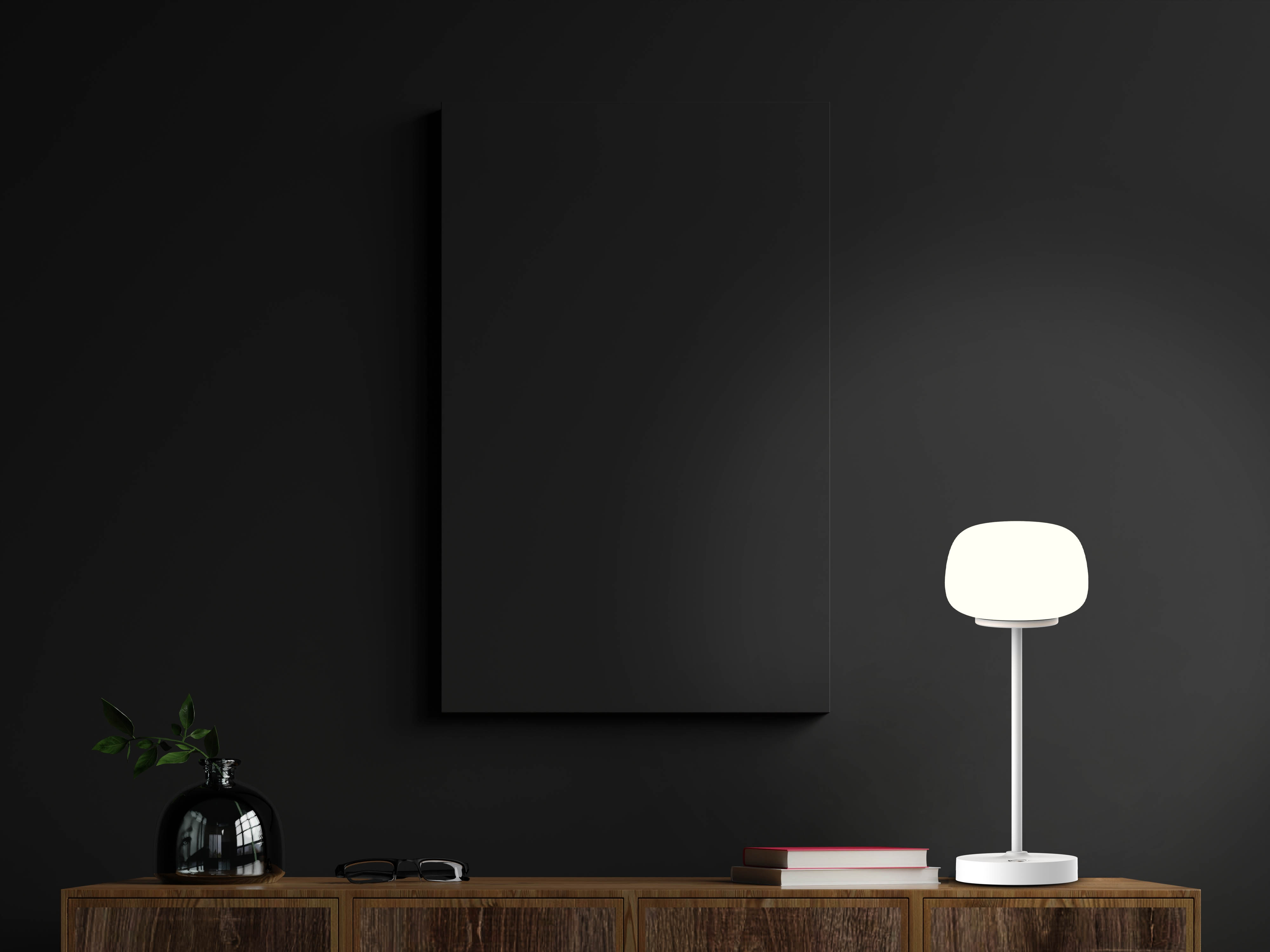 Schwarze Wand mit schwarzem Leinwandrahmen, Holzschrank mit Lampe und Dekorationen.